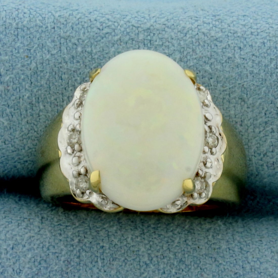 Vintage Opal and Diamond Ring in 14k Yellow Gold: In 14k Yellow Gold. Contains one 16x12mm high quality natural Opal gemstone with flashes of orange, yellow, blue, and green. Also contains six high quality .01ct diamonds. Size 7. 6.8g.
