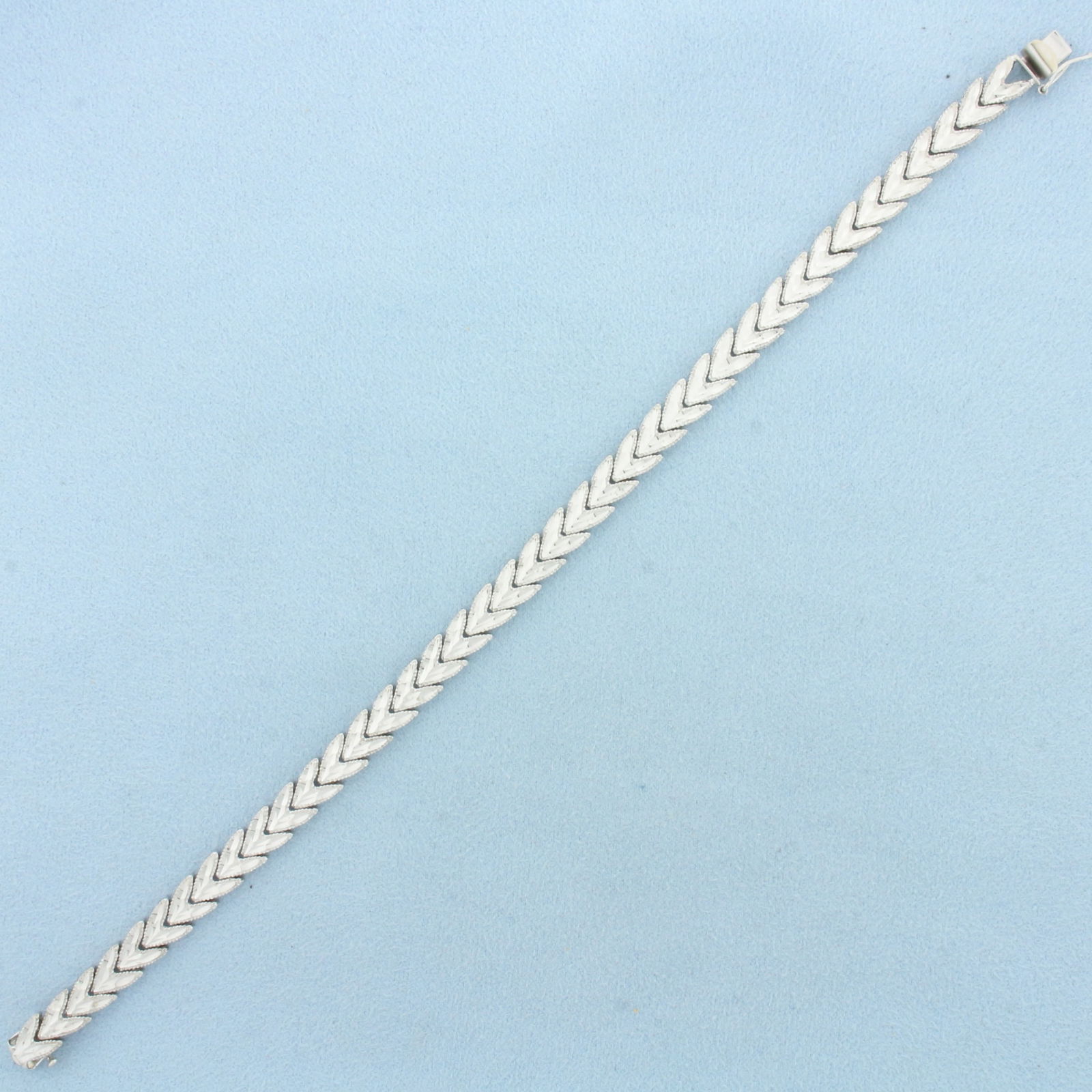 Diamond Cut Chevron Link Bracelet in 14k White Gold: In 14k White Gold. 8 1/8 inches long. 6.3mm wide. Concealed slide clasp with safety latch. Concealed slide clasp with safety latch. 11.7g.