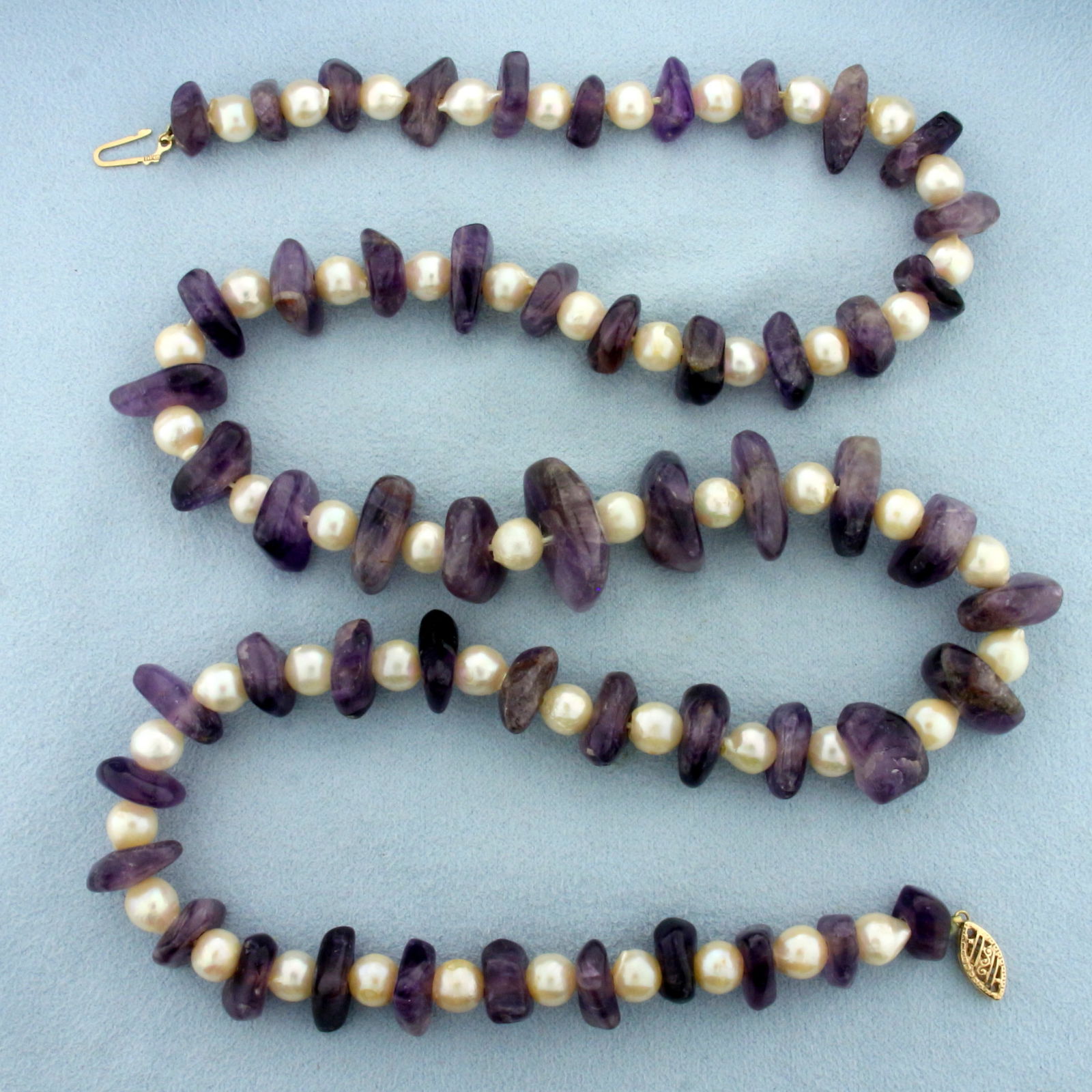 24 Inch Pearl and Amethyst Bead Necklace with 10k Yellow Gold Clasp: 10k yellow gold clasp. Contains 6 to 6.5mm freshwater Cultured Pearls with high luster. Polished amethyst gemstone beads measure 16mm to 19mm with intense purple color. Filigree design clasp. 71.7g.