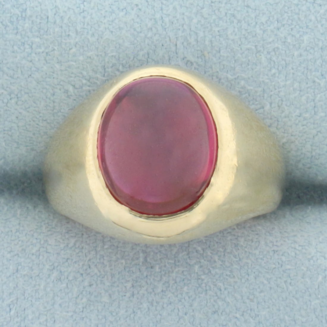 Lab Ruby Ring in 10k Yellow Gold: In 10k yellow gold. Contains one oval cabochon lab ruby gemstone, 12mm x 10mm, with vibrant ruby red color and excellent clarity. Size 6.5 9.7g.