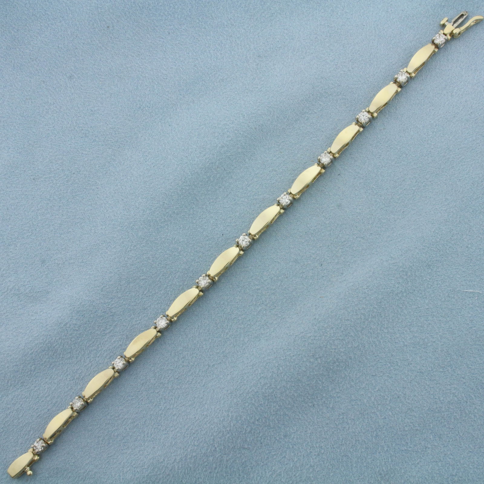 Diamond Bracelet in 14k Yellow Gold: In 14k Yellow Gold. Contains eleven high quality diamonds, 1.5ct TW, VS clarity/H color. 7 1/4 inches long. 4.1mm wide. Concealed slide clasp with safety latch. 12.6g.