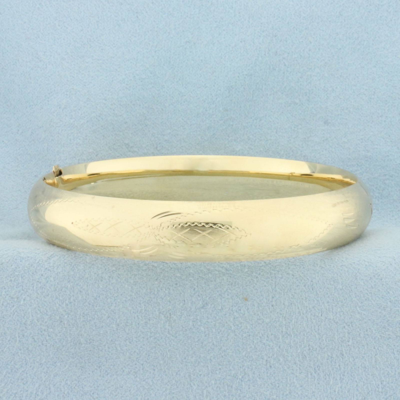 Etched Hinged Bangle Bracelet in 14k Yellow Gold: In 14k Yellow Gold. Interior dimensions: 2 3/8 by 2 1/4 inches. 10mm wide. Hinged slide locking clasp. 14.0g.
