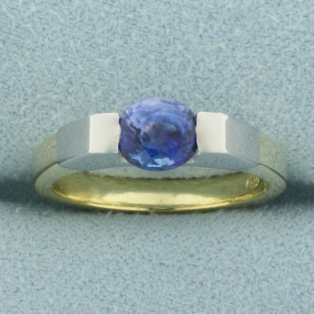 AAA Ceylon Sapphire Tension Set Ring in 18k Yellow and White Gold: In 18k Yellow Gold. Contains one 6x5.5mm high quality oval cut natural Ceylon Sapphire gemstone, approximately 1ct, with intense color and excellent clarity. Size 5.75. 6.1g.