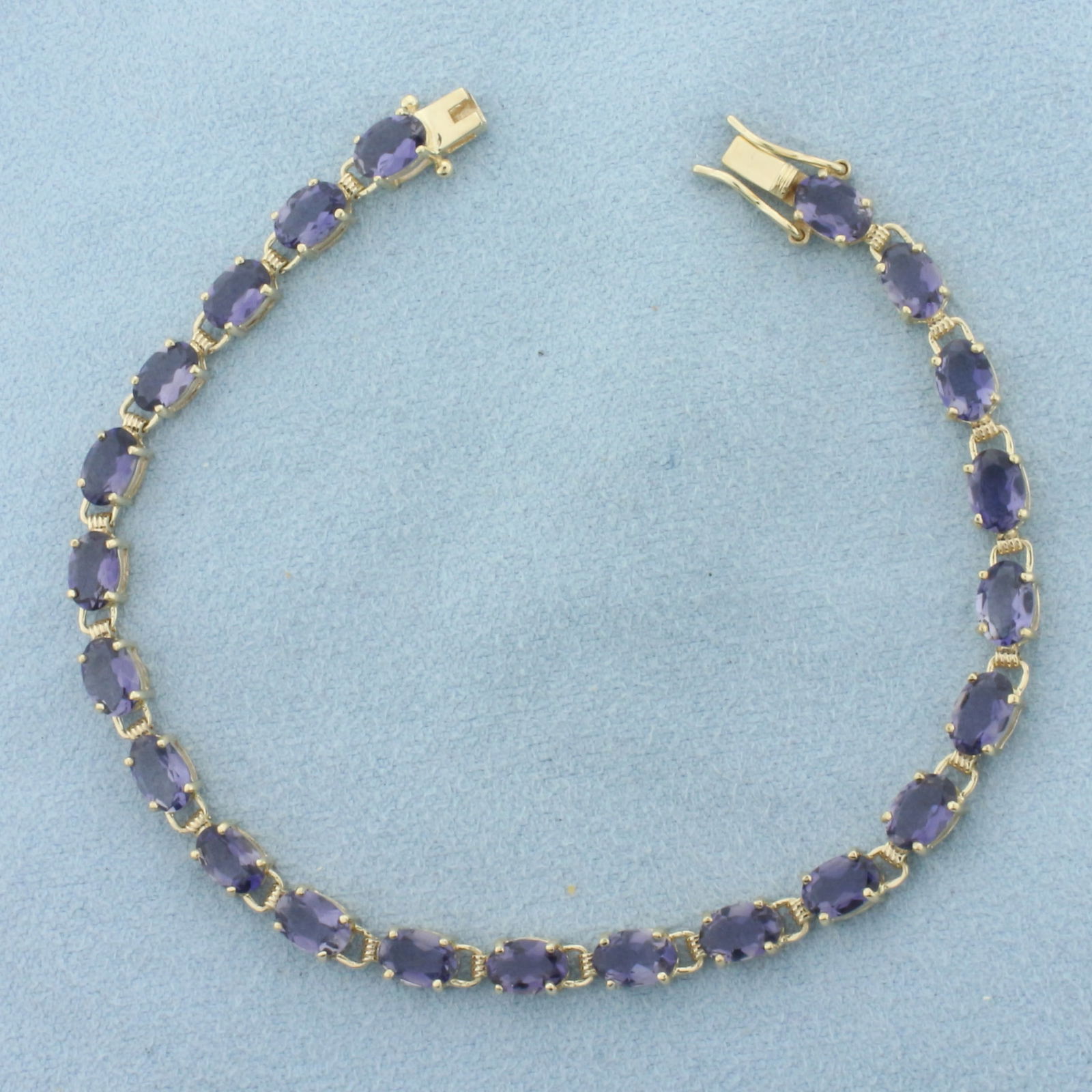 Tanzanite Tennis Bracelet in 10K Yellow Gold: In 10k yellow gold. Measures 7 inches long. Contains 22 high quality natural 6mm Tanzanite gemstones, approximately 11ct TW, with bright color and excellent clarity. Slide clasp with double safety lat