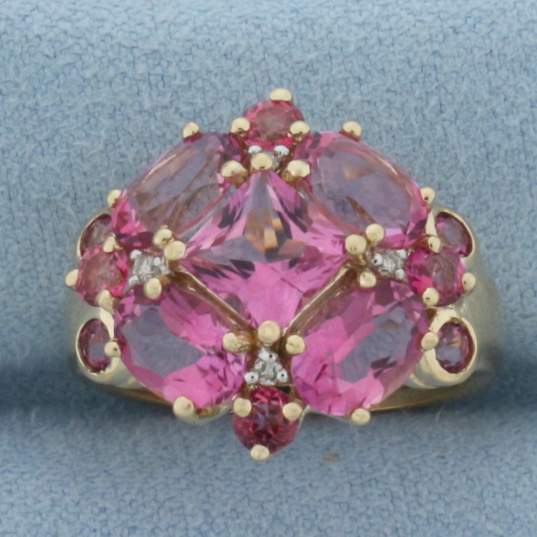 Pink Tourmaline and Diamond Ring in 10k Yellow Gold: In 10k Yellow Gold. Contains one 6mm princess cut, four 5x7mm oval cut, and eight 3mm round cut high quality natural Pink Tourmaline gemstones, with bright color and excellent clarity. Also contains f