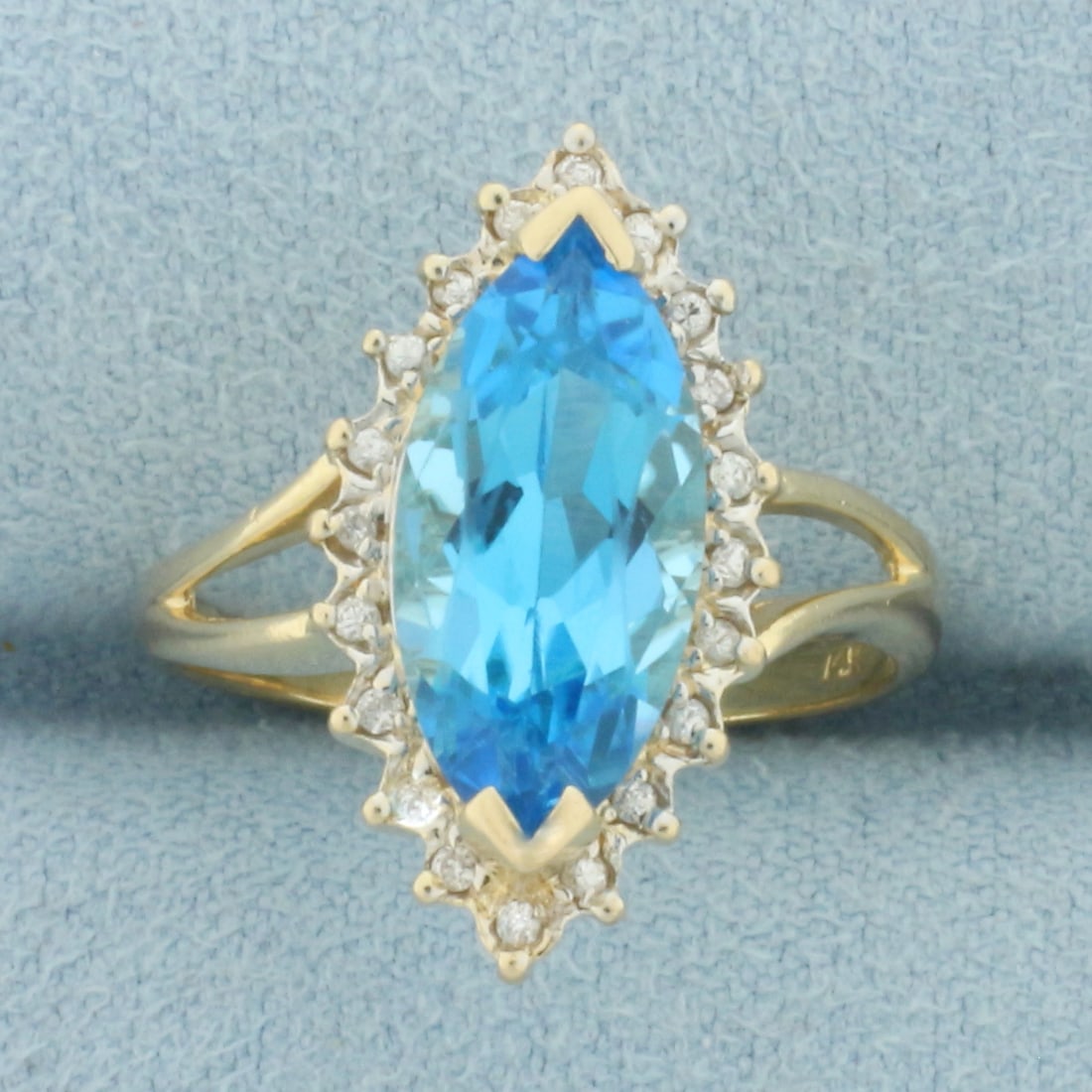 Swiss Blue Topaz and Diamond Ring in 14k Yellow Gold: In 14k Yellow Gold. Contains one 15x7mm high quality marquise cut natural Swiss Blue Topaz gemstone, approximately 3cts, with electric blue color and excellent clarity. Also contains twenty high quali