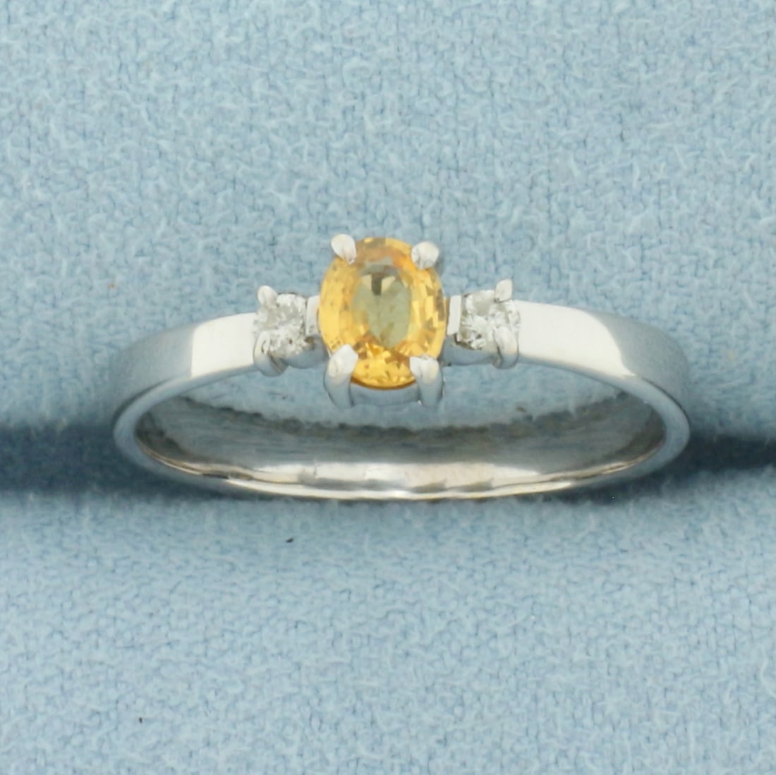 Orange Sapphire and Diamond Ring in 18k White Gold: In 18k White Gold. Contains one 5x4mm high quality natural Orange Sapphire gemstone, approximately 1/3ct, with intense color and excellent clarity. Also contains two high quality .04ct diamonds, SI cl