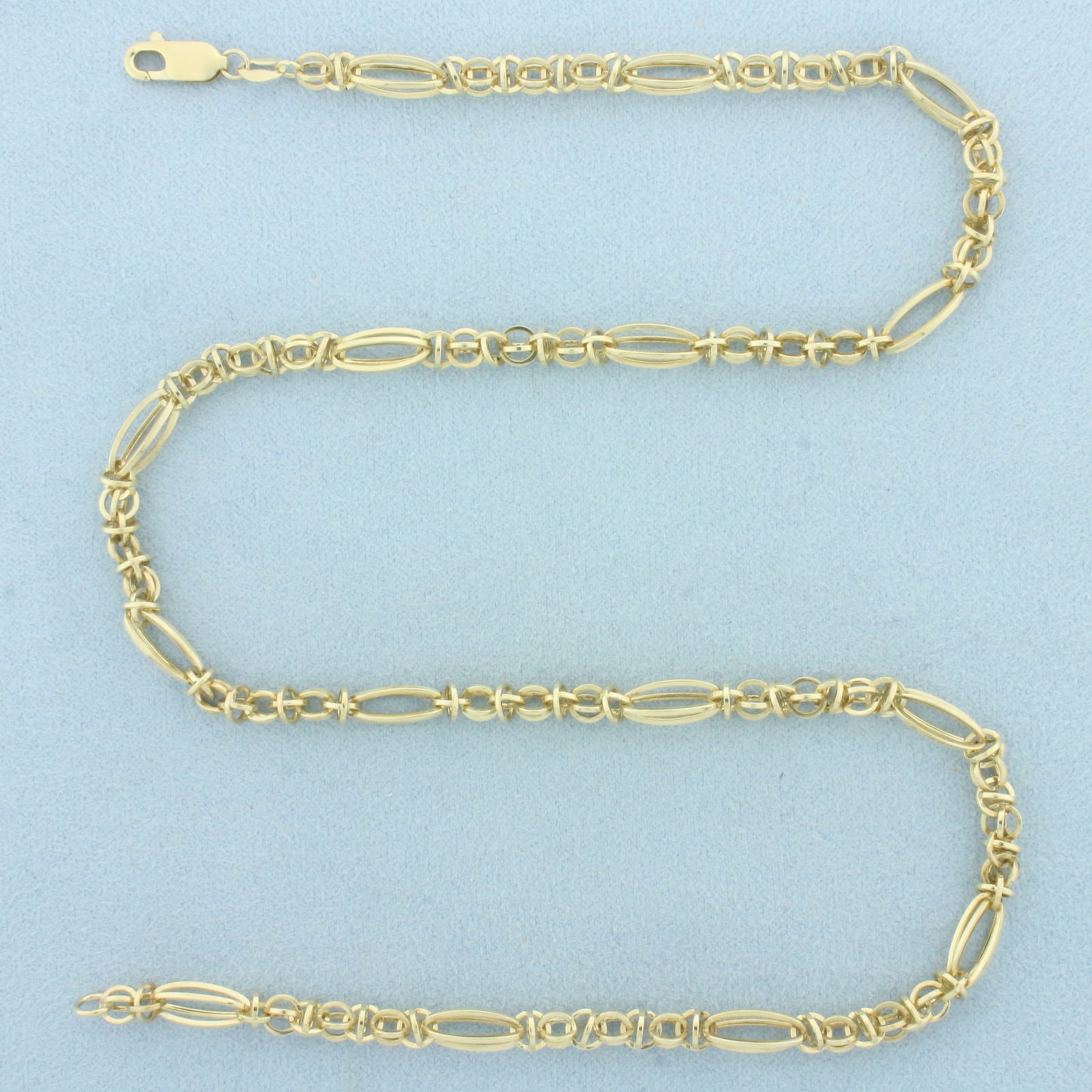 18 Inch 3D Figaro Oval and Round Link Necklace in 10k Yellow Gold: In 10k Yellow Gold. 18 inches long. 5.3mm wide at widest. Lobster clasp. 8.4g.