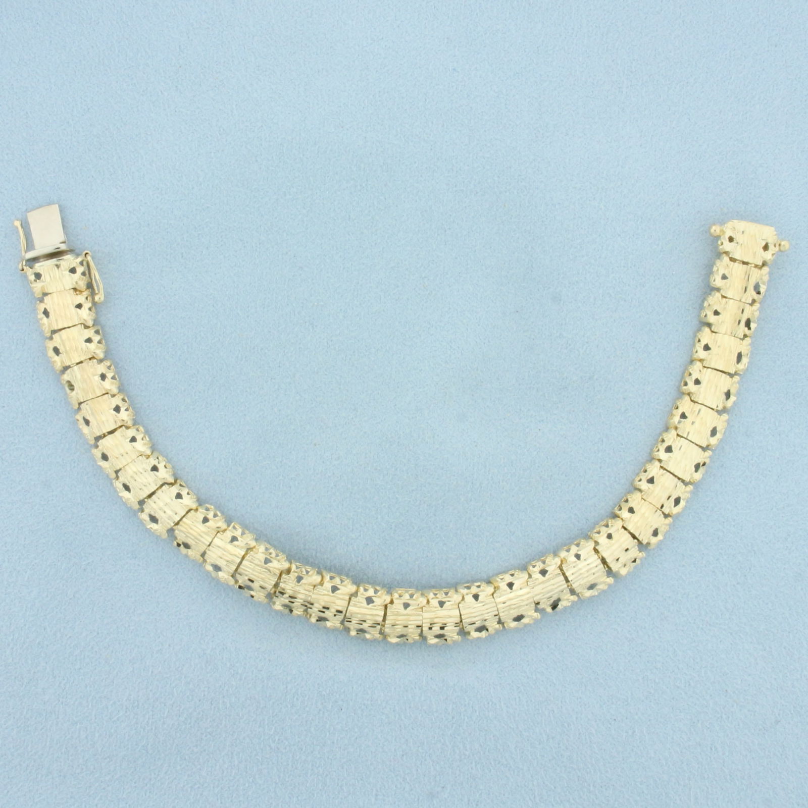 Designer Cutout Nugget Link Bracelet in 14k Yellow Gold: In 14k yellow gold. 7.25 inches long, 3/8inch wide. Concealed slide clasp with 2 safety latches. 17.7g.