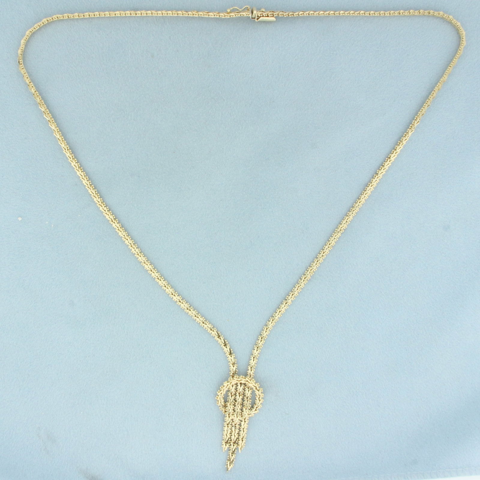18 Inch Riccio Tassel Necklace in 14k Yellow Gold: In 14k yellow gold. 18 inches long, center design measures 1 3/8 inches long and 5/8 inches wide. Slide clasp with safety latch. 18.2g.
