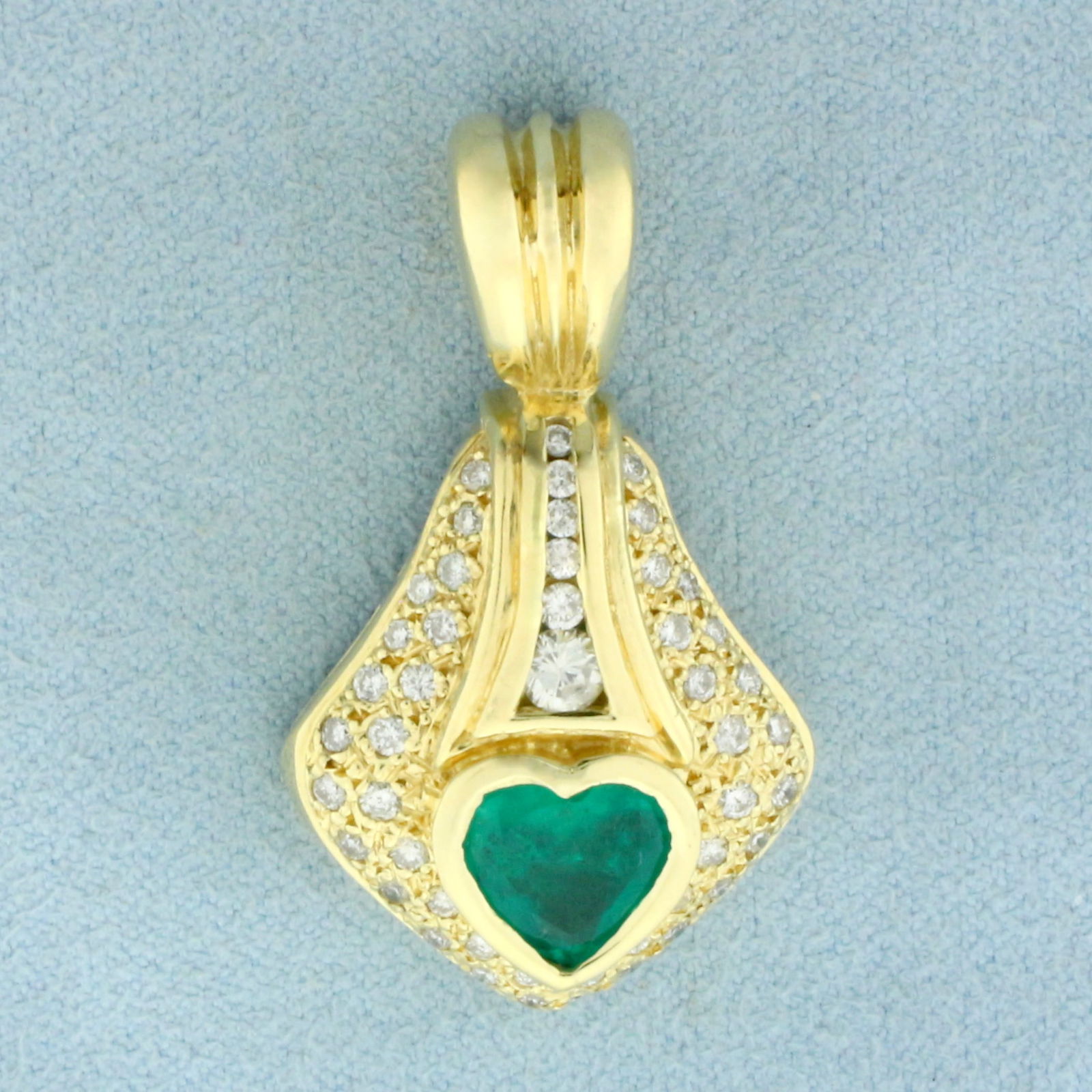 Heart Emerald and Diamond Pendant in 14k Yellow Gold: In 14k Yellow Gold. Contains one 9mm high quality heart Emerald gemstone, approximately 1.5cts, with vibrant color. Also contains forty eight high quality diamonds, 3/4ct TW, SI clarity/H color. 1 3/8