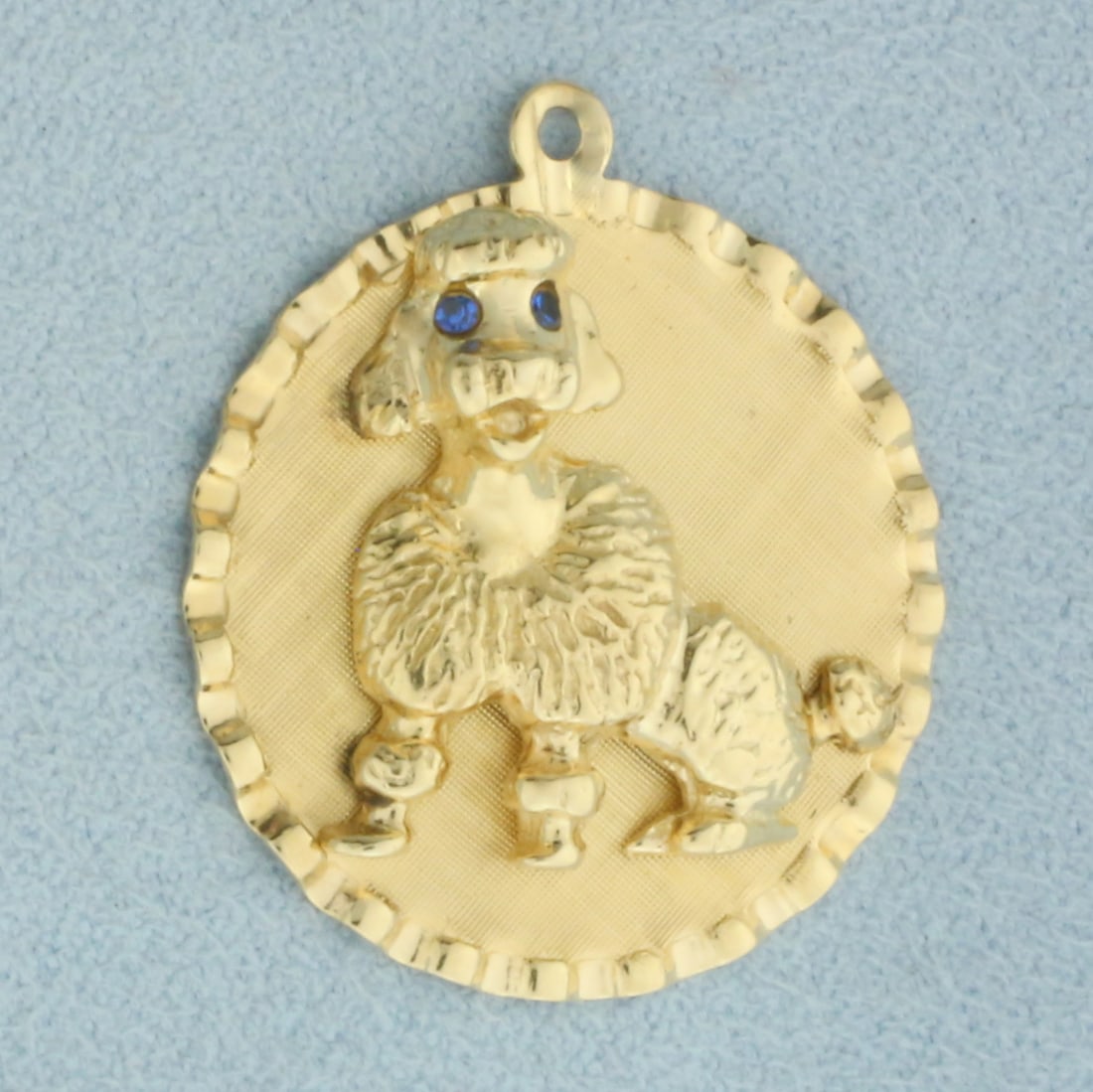 Engravable Poodle Dog Charm or Pendant in 14k Yellow Gold: In 14k Yellow Gold. Contains two 1.5mm high quality Sapphire gemstones for eyes. 1 1/8 inch long. 1 inch wide. Blank back to engrave name or date. 5.8g.