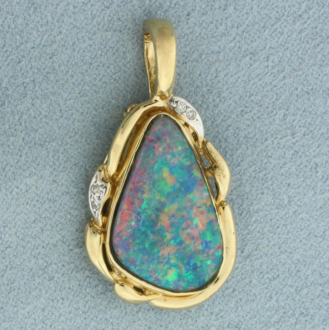 Australian Boulder Opal and Diamond Pendant in 14k Yellow Gold: In 14k Yellow Gold. Contains one 21x13mm high quality natural doublet Australian Boulder Opal gemstone with excellent play of color. Also contains four high quality 1/2pt diamonds. 1 1/4 inch long (in