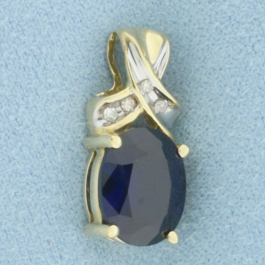 Lab Sapphire and Diamond Pendant in 10k Yellow Gold: In 10k Yellow Gold. Contains one 10x8mm high quality oval cut Lab created Sapphire gemstone, approximately 3cts, with intense color and excellent clarity. Also contains four high quality 1/2pt diamond