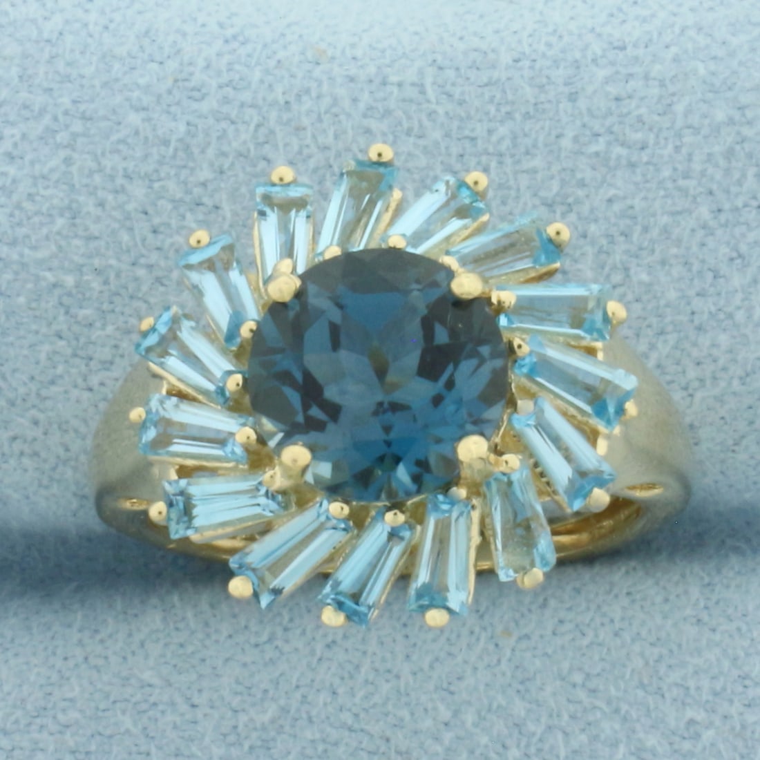 London Blue Topaz Sunburst Ring in 14K Yellow Gold: In 14k yellow gold. Measures 17mm wide at top of ring. Contains 1 high quality natural 9mm London Blue Topaz gemstone, approximately 2.5ct with intense color and excellent clarity. Also contains 15 ta