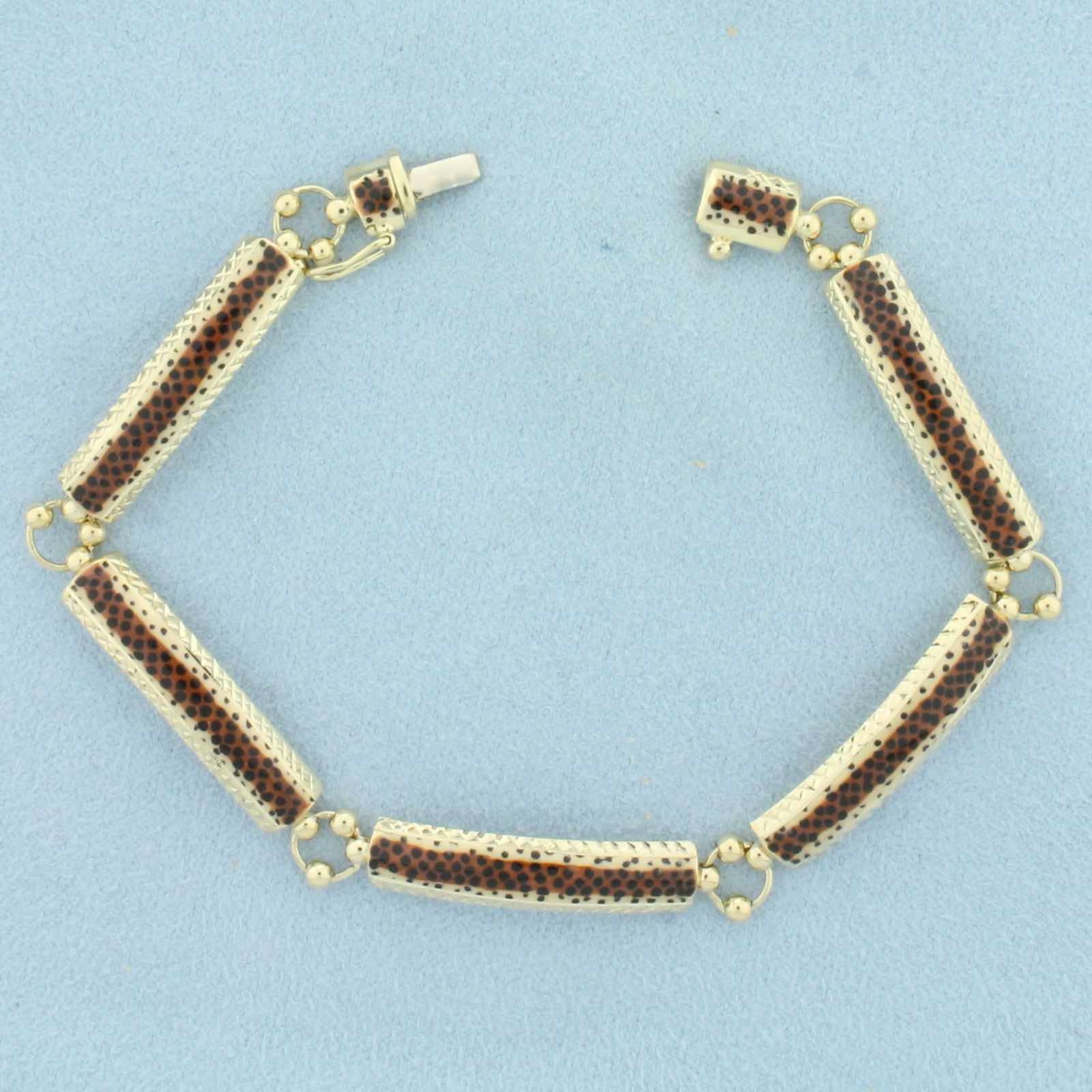 Animal Print Bracelet in 14k Yellow Gold: In 14k Yellow Gold. 7 3/8 inches long. 1/4 inch wide. Slide clasp with safety latch. 7.8g.