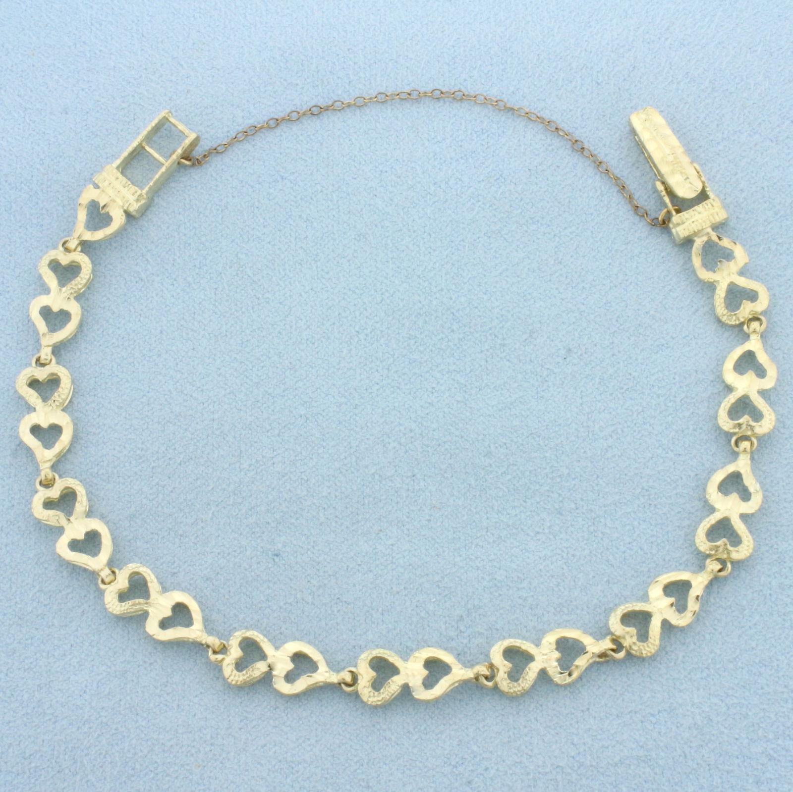 Diamond Cut Heart Link Bracelet in 10k Yellow Gold: In 10k Yellow Gold. 7 1/4 to 7 1/2 inches long (adjustable). 6.6mm wide. Locking clasp with safety chain. 7.6g.
