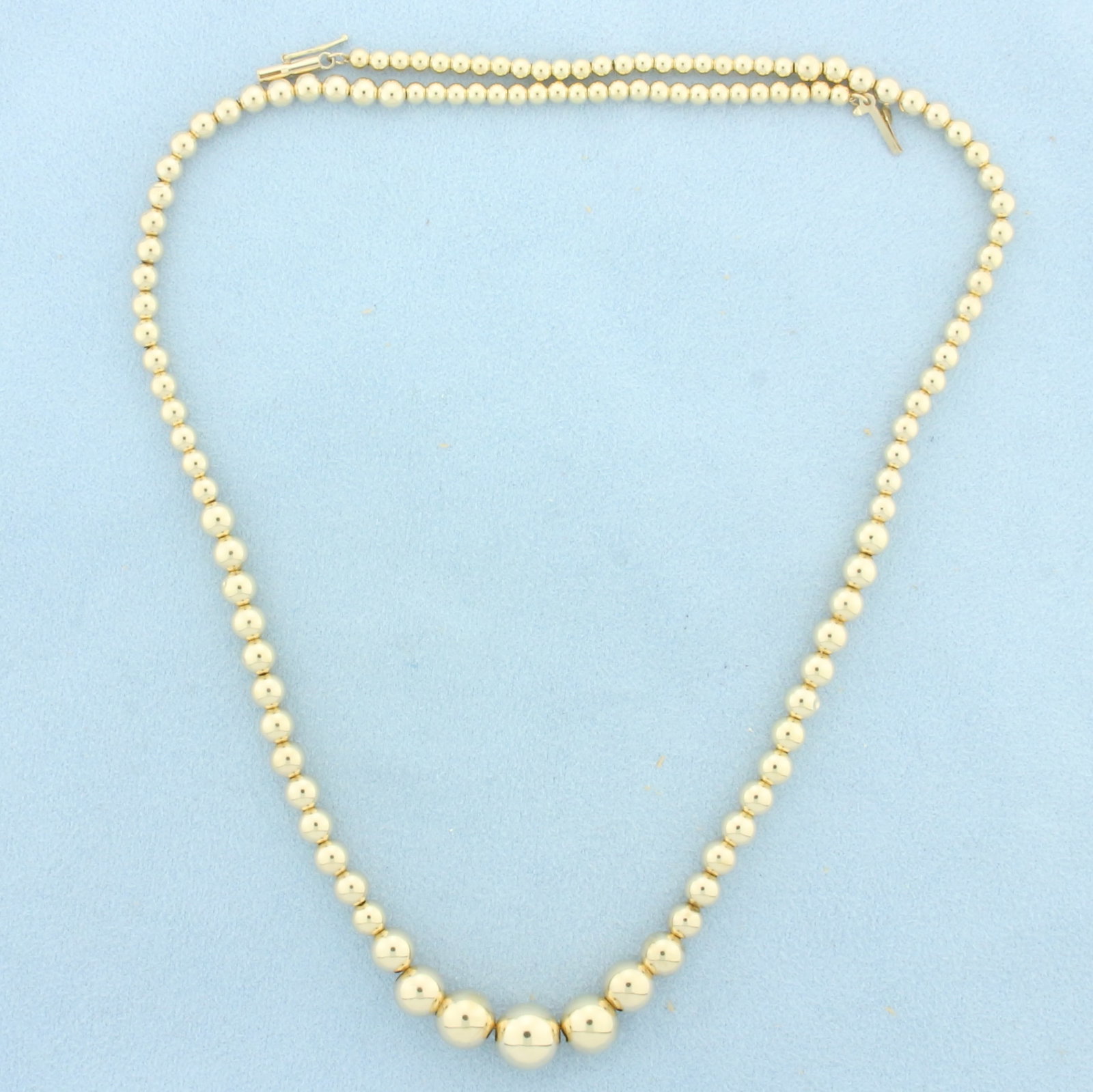 18 Inch Graduated Ball Bead Necklace in 14k Yellow Gold: In 14k Yellow Gold. 18 inches long. Beads 3-9mm. Barrel clasp with safety latch. 5.0g.