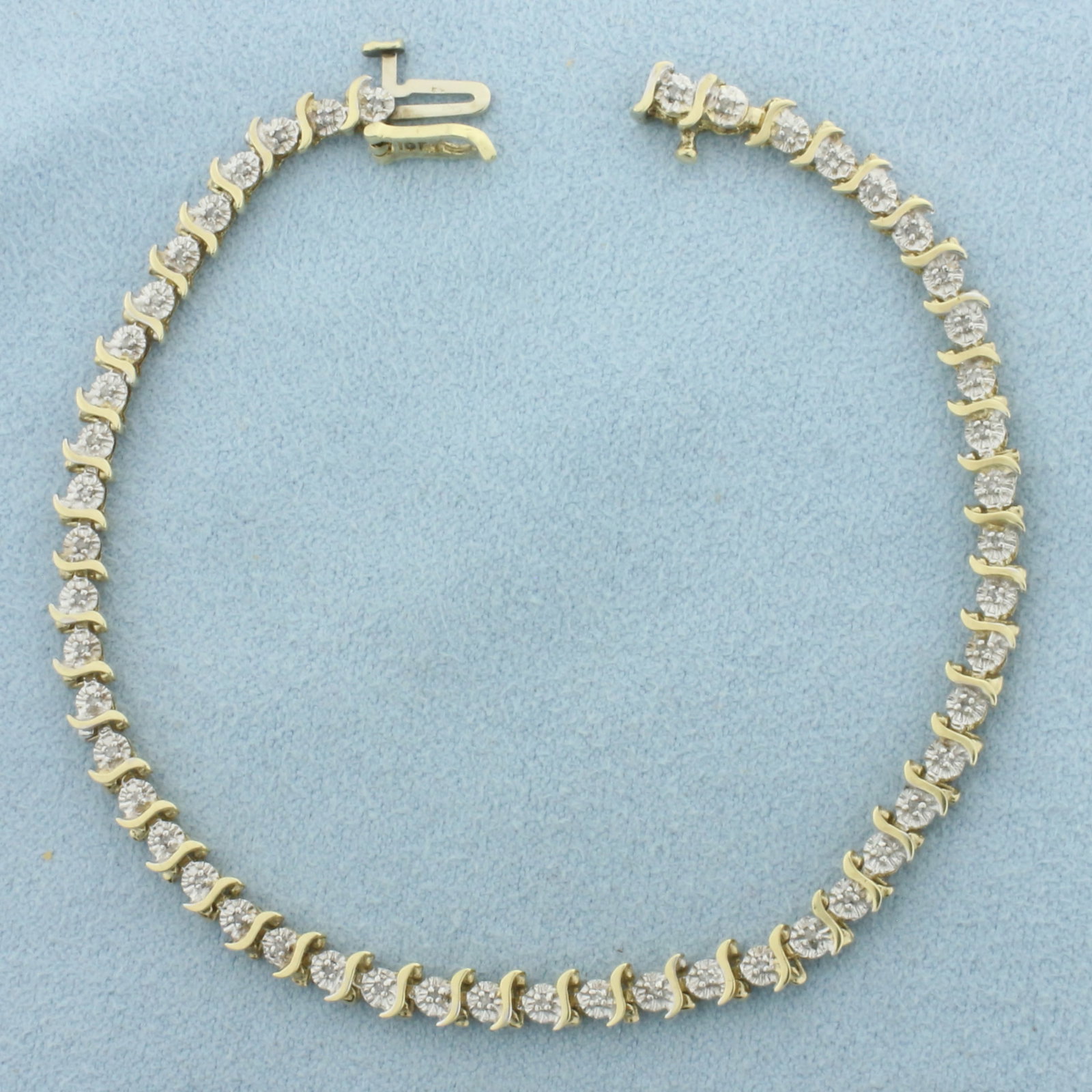 Diamond S-Link Tennis Bracelet in 10k Yellow Gold: In 10k Yellow Gold. Contains fifty high quality 1/2pt diamonds. 7.25 inches long. 4mm wide. Concealed slide clasp with safety latch. 5.2g.