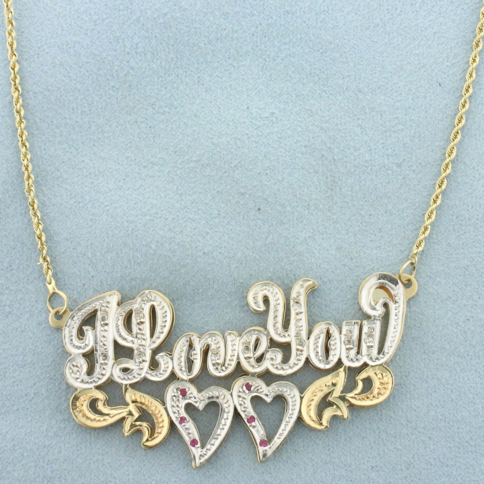 Diamond and Pink Sapphire "I Love You" Heart Necklace in 14k Yellow and White Gold: In 14k yellow and white gold. Contains 10 high quality 1/2pt diamonds. Also contains 6 high quality 1.25mm pink sapphire gemstones with intense color and excellent clarity. Center is 2 1/4 inches wide