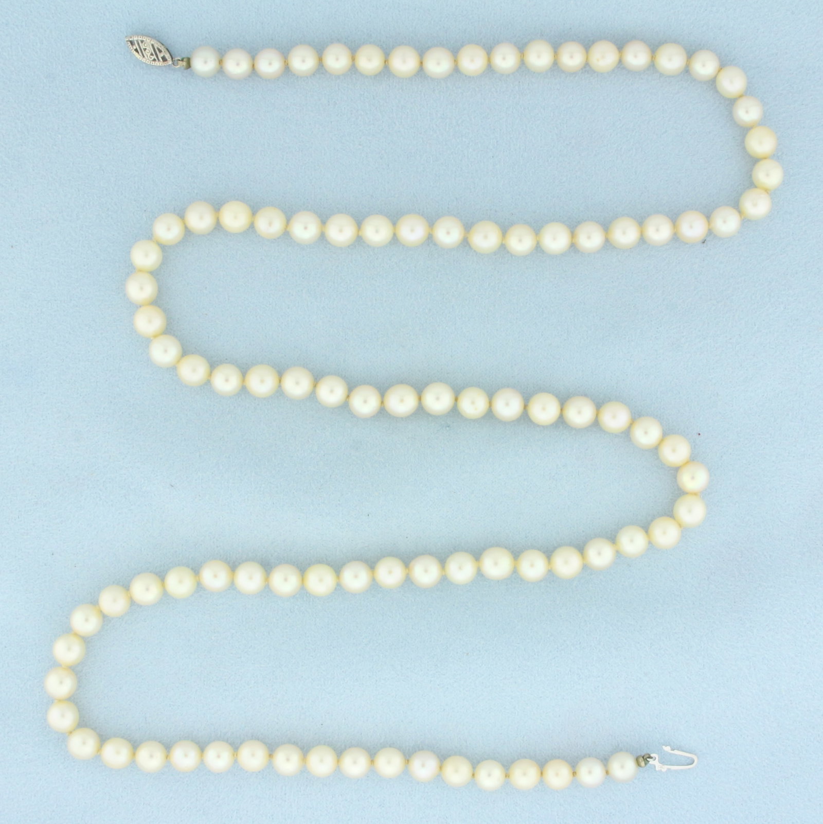 Cultured Akoya Pearl Strand Necklace in 10k White Gold: In 10k white gold. Contains 6.5mm Cultured Akoya pearls with high luster. Hand knotted. 27 inches long. Decorative filigree locking clasp. 35.2g.