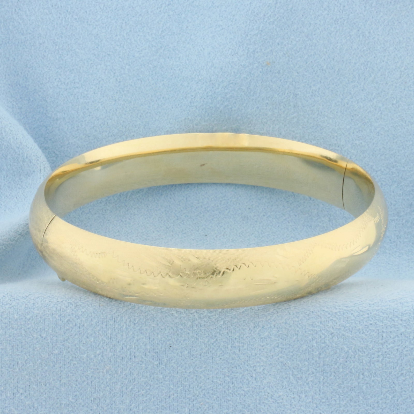 Etched Design Hinged Bangle Bracelet in 14k Yellow Gold: In 14k Yellow Gold. Interior dimensions: 2 1/4 inch by 2 1/8 inch. 10.5mm wide. Hinged closure. 14.2g.