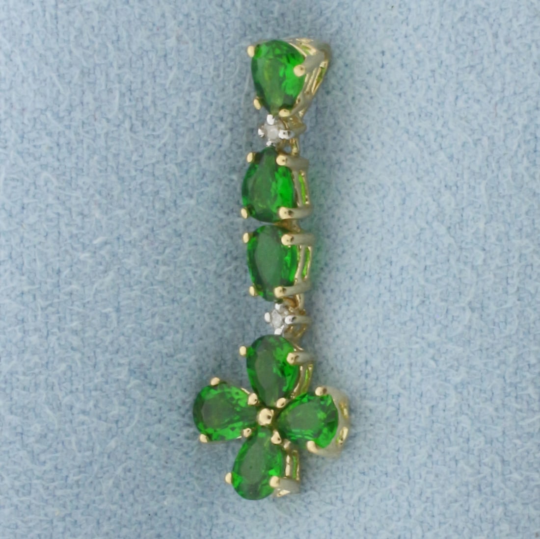 Green Garnet and Diamond Flower Dangle Pendant in 10k Yellow Gold: In 10k yellow gold. 1" long x 3/8"wide. Contains seven high quality natural 4mm pear Garnet gemstones with vibrant color and excellent clarity. Also contains two high quality 1/2pt diamonds. 0.9g