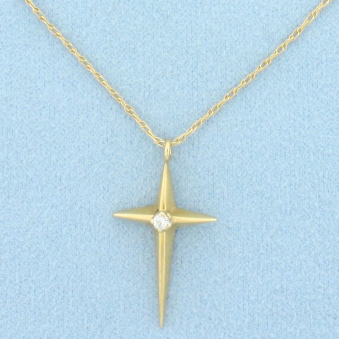 Diamond Cross Necklace in 14k Yellow Gold: In 14k Yellow Gold. Contains one .04ct high quality diamond, VS clarity/H color. Cross is 1 inch long by 1/2 inch wide . Prince of Wales Chain is 22 inches long, 0.8mm wide. Spring clasp. 3.3g.