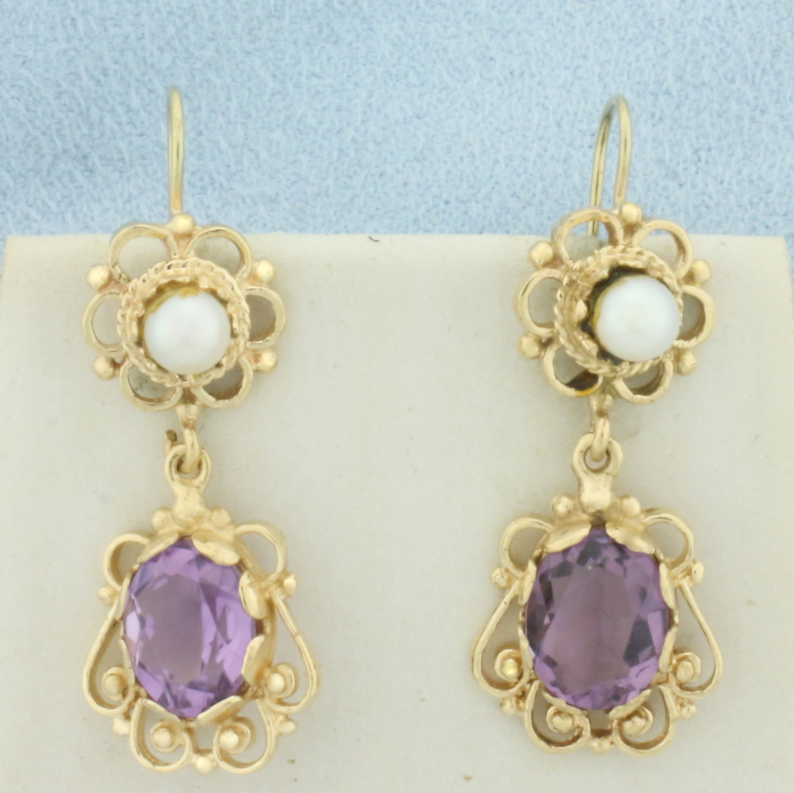 Amethyst and Cultured Pearl Dangle Earrings in 14k Yellow Gold: In 14k Yellow Gold. Contains two 10x7mm high quality natural Amethyst gemstones with bright color and excellent clarity. Also contains two 4mm high quality Cultured Pearls with high luster. 1 1/4 inch