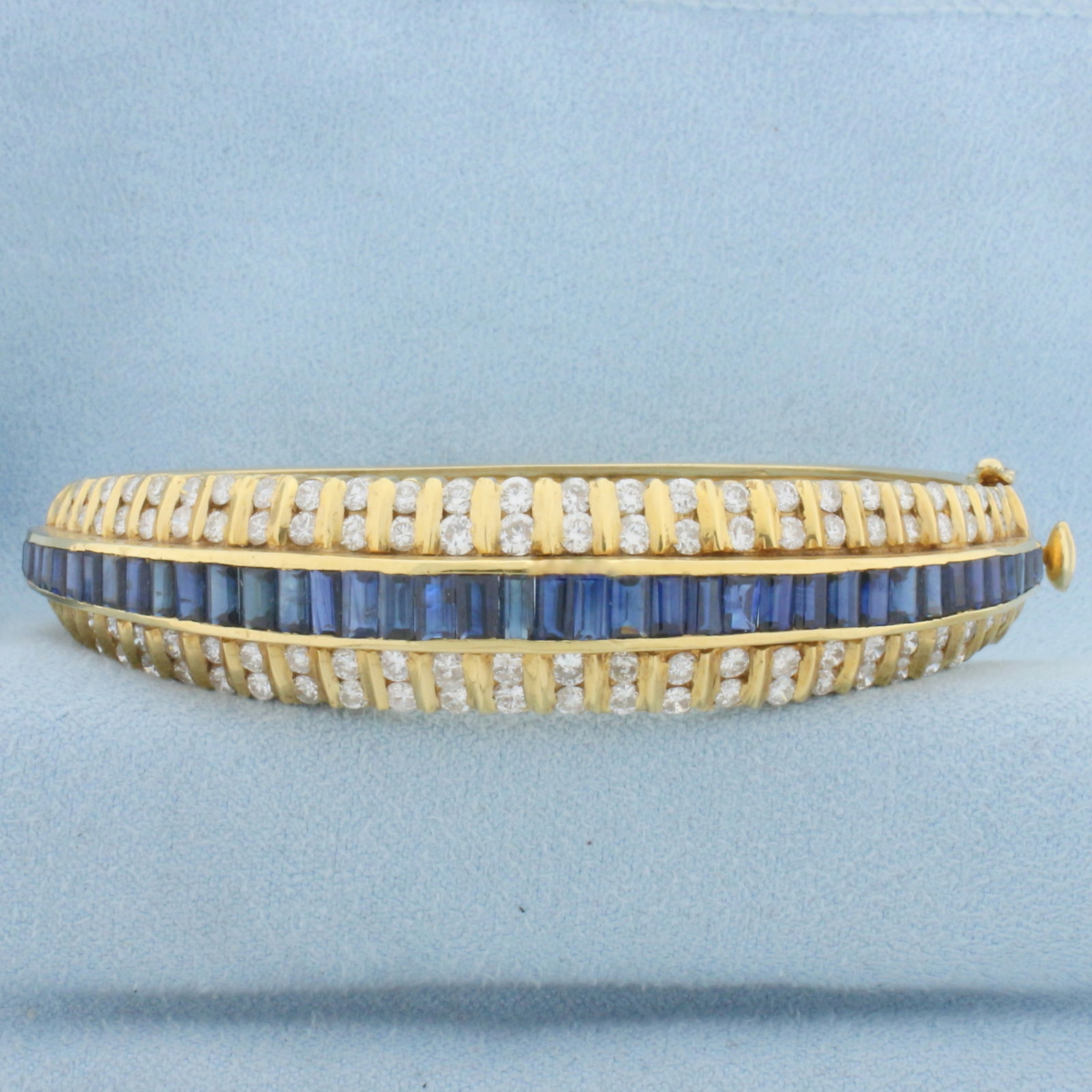 Designer 5ct Sapphire and Diamond Bangle Bracelet in 18k Yellow Gold: In 18k yellow gold. Contains 3ct TW of high quality round brilliant diamonds, VS clarity/G color. Also contains forty baguette shaped high quality natural sapphires ranging from 2.5mm to 4mm long each