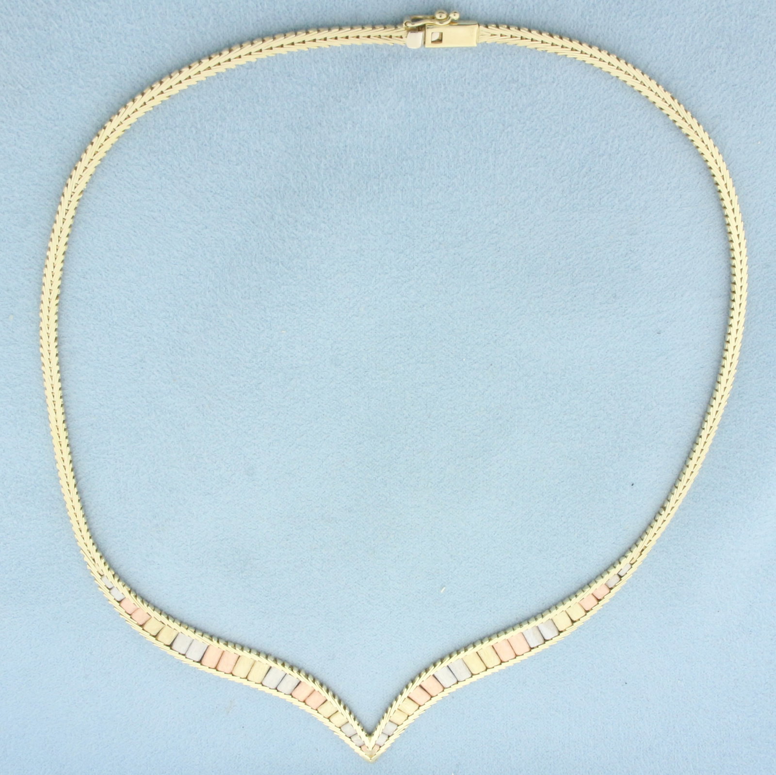 16 Inch Italian Tri-Color Gold V Choker Necklace in 14k Yellow, White, and Rose Gold: In 14k Yellow, White, and Rose Gold. 16 inches long. 7.5mm wide at widest. Italian made. Slide clasp with safety latch. 20.8g.