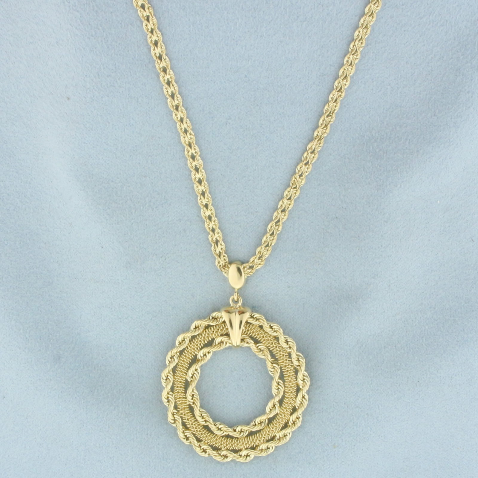 Rope Circle Medallion Necklace in 14k Yellow Gold: In 14k Yellow Gold. Rope chain is 17 1/2 inches long, 3mm wide. Pendant is 1 3/4 by 1 1/4 inch. Lobster clasp. 6.9g.