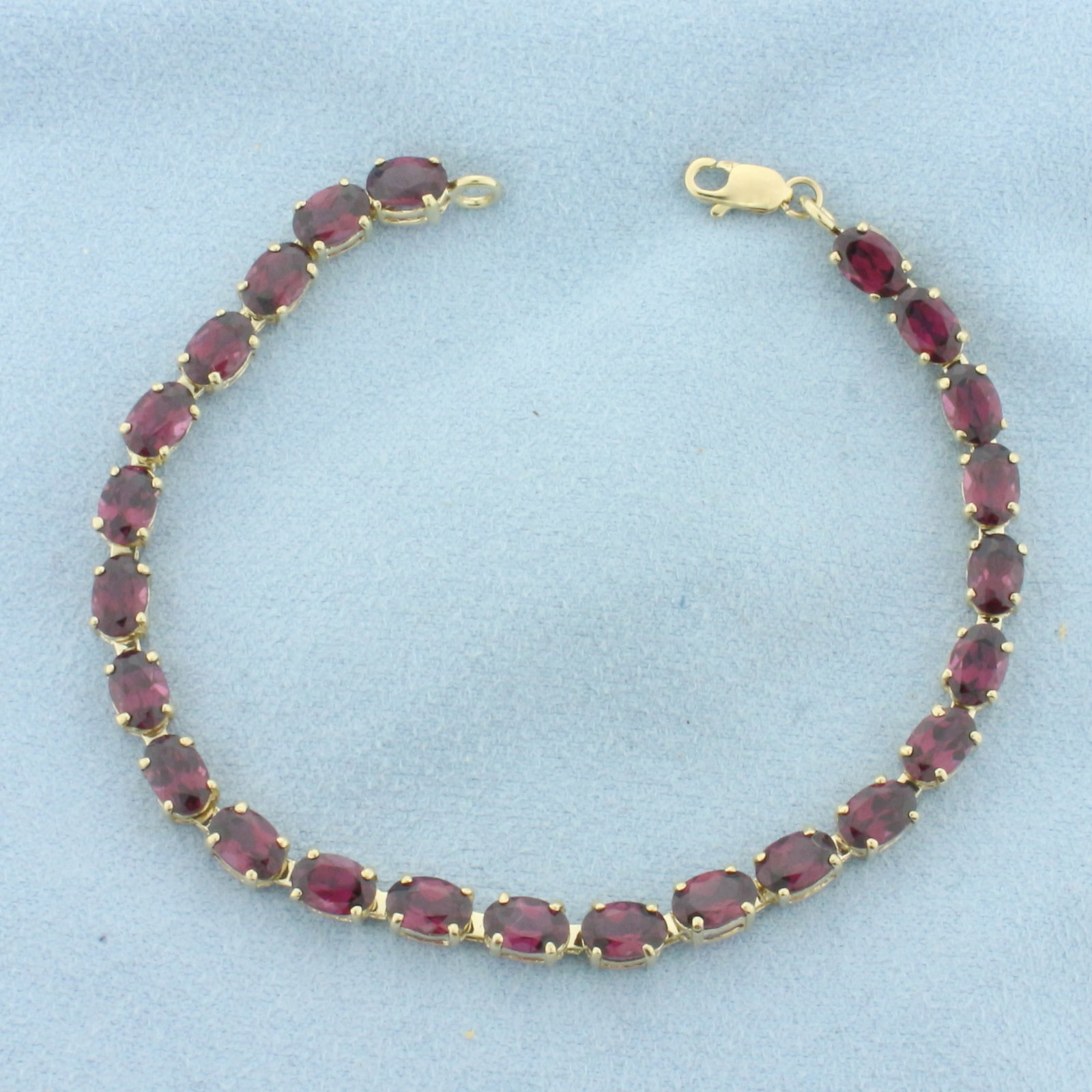 Garnet Tennis Bracelet in 10k Yellow Gold: In 10k Yellow Gold. Contains twenty-four 4x6mm high quality natural Garnet gemstones, approximately 12ct TW, with intense color and excellent clarity. 7 inches long. Lobster clasp. 7.0g.