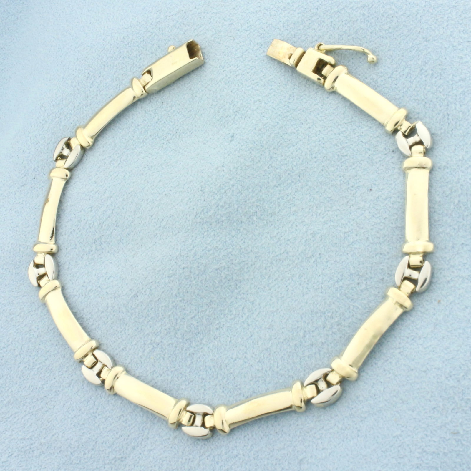 Two Tone Link Bracelet in 14k Yellow and White Gold: In 14k Yellow and White Gold. 7 3/8 inches long. 5.5mm wide. Slide clasp with safety latch. 11.0g.