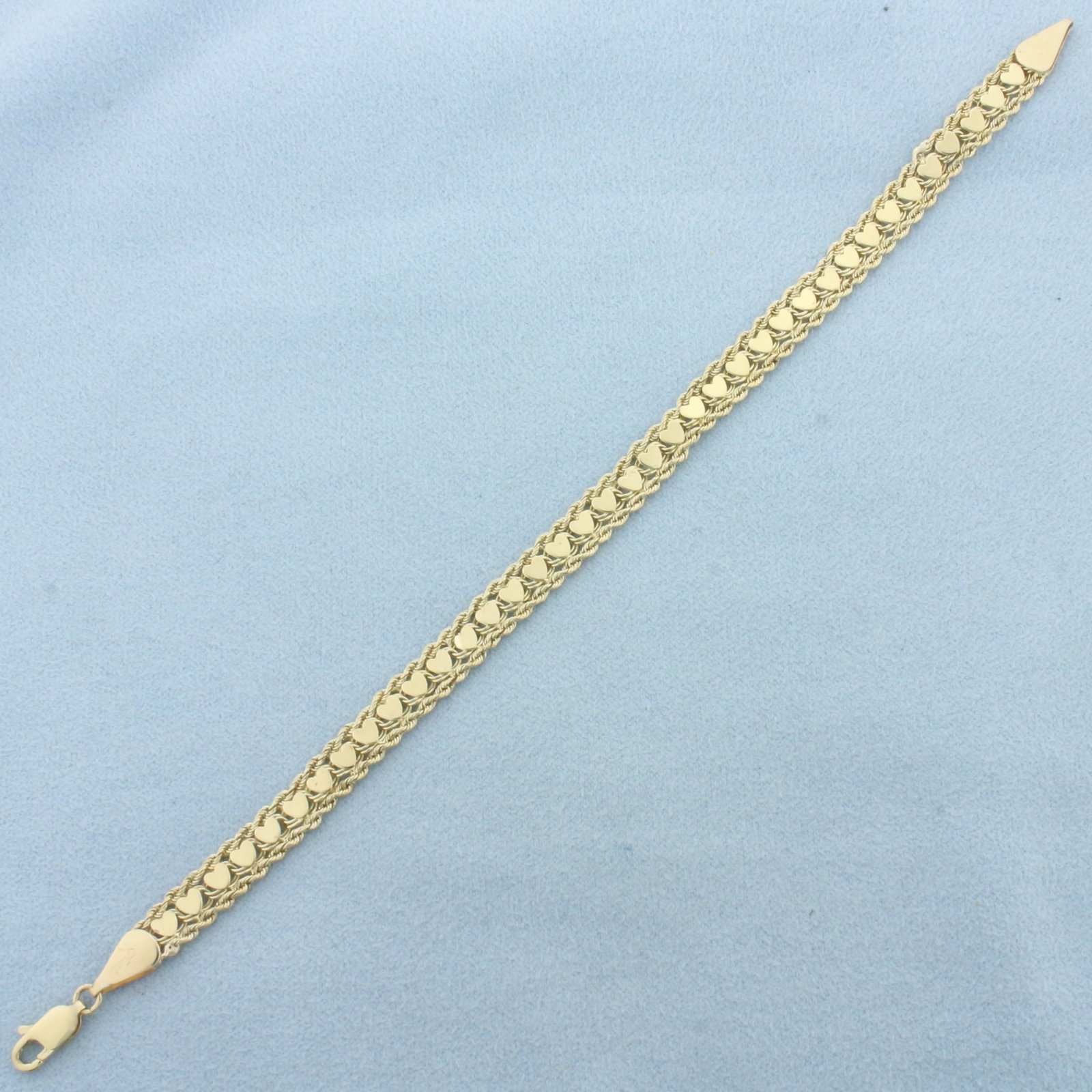 Heart Link Rope Bracelet in 14k Yellow Gold: In 14k Yellow Gold. 7 1/8 inches long. 1/4 inch wide. Lobster clasp. 6.4g.