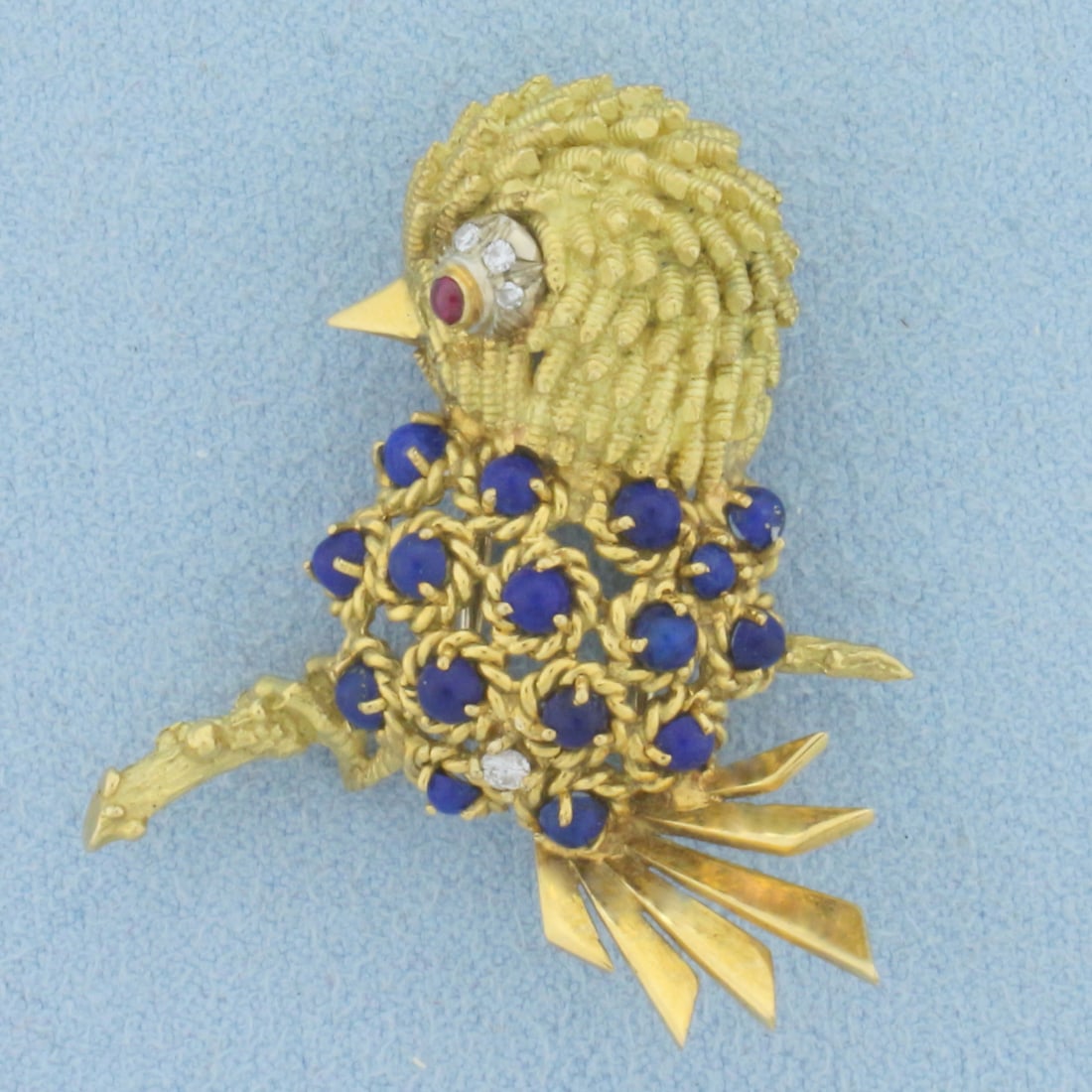 Italian Made Lapis, Ruby, and Diamond Bird Pin in 18K Yellow Gold: In 18K Yellow Gold. Contains sixteen high quality natural 2.5mm round cut Lapis gemstones with intense blue color. Also contains one high quality 1.8mm ruby with bright color and excellent clarity. Al