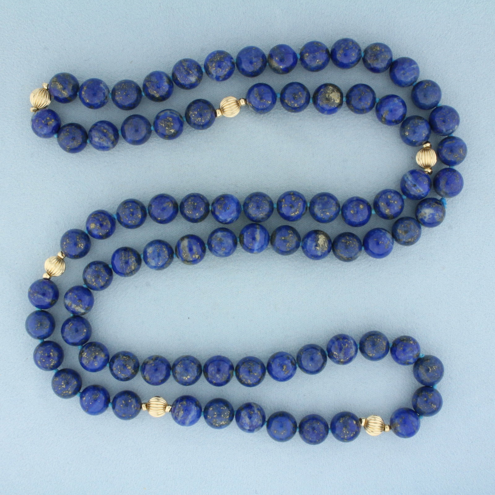 Lapis Lazuli and 14k Gold Bead Hand Knotted Strand Necklace: 14k gold beads. Contains high AAA quality 10mm lapis lazuli gemstone beads with intense color and gold fleks throughout. Also contains 7mm gold scalloped bead s. 36 inches long. Hand knotted. 136.3g.