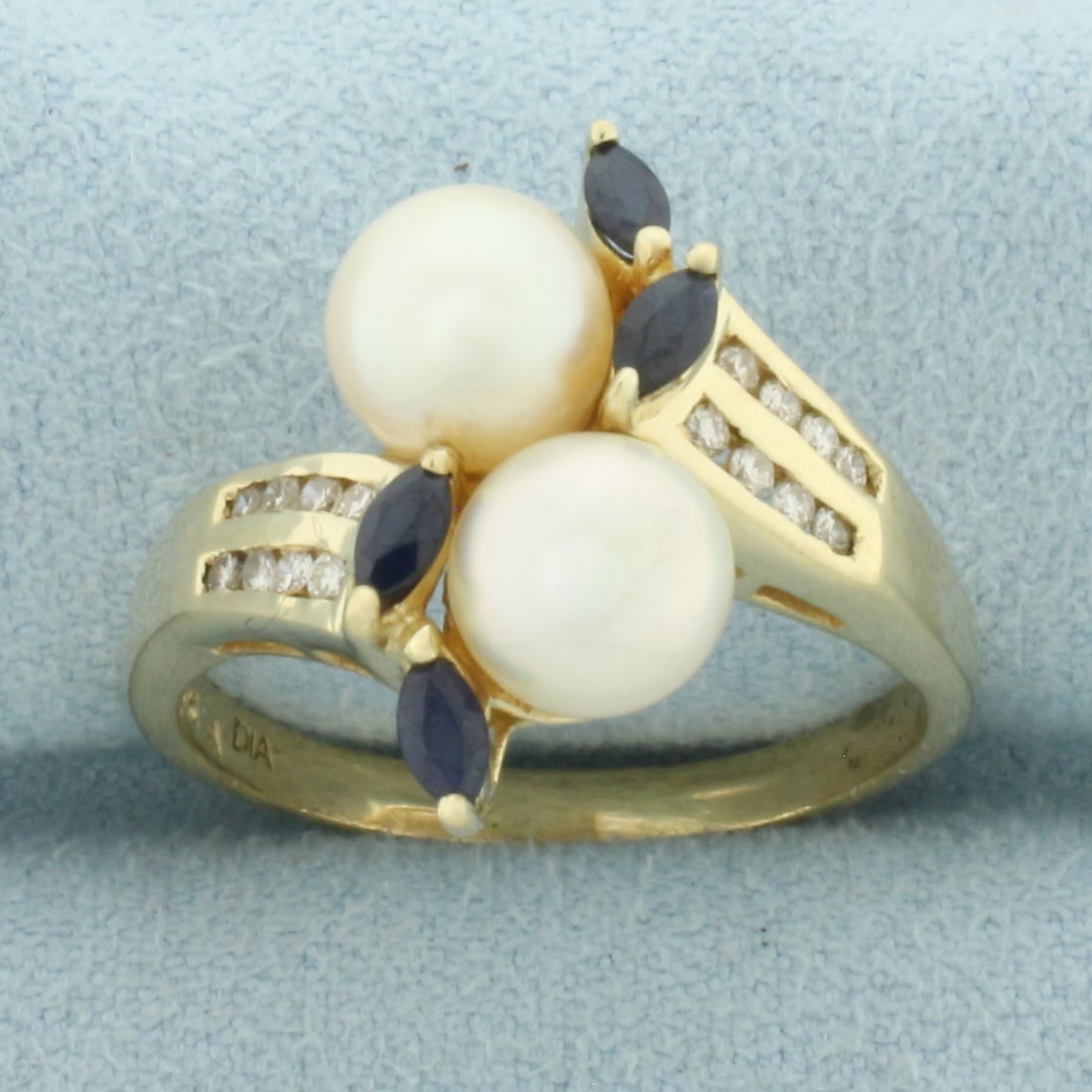 Akoya Pearl, Sapphire, and Diamond Toi et Moi Ring in 14k Yellow Gold: In 14k Yellow Gold. Contains two 7mm high quality Cultured Akoya Pearls, one with silver undertone and one with pink undertone. Both with high luster. Also contains four 4mm high quality natural Sapph