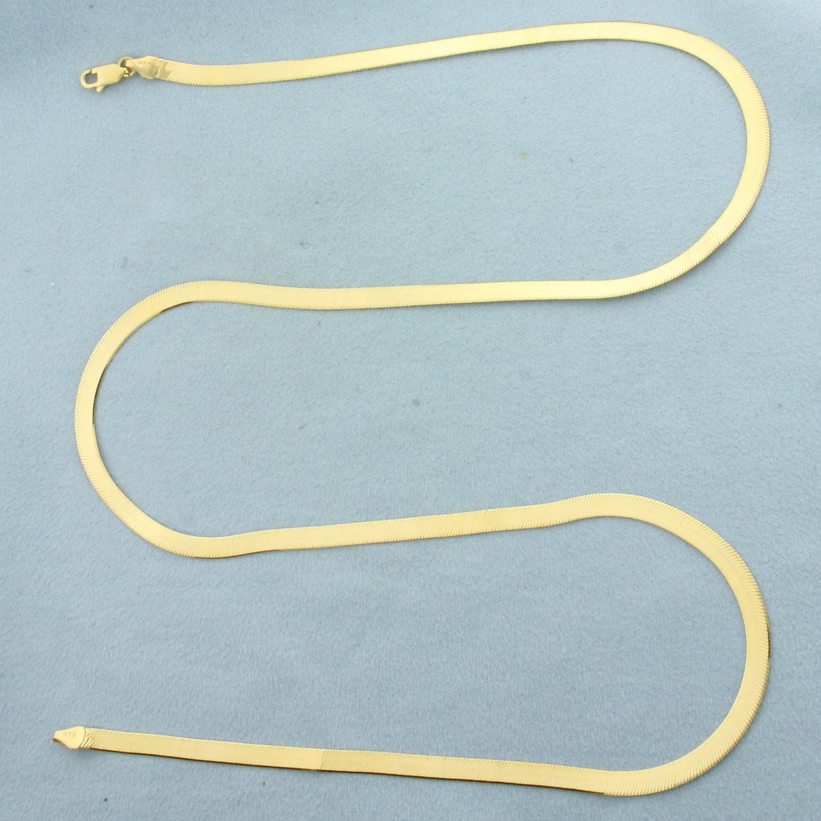 24 Inch Reversible Herringbone Link Chain Necklace in 14k Yellow Gold: In 14k Yellow Gold. 24 inches long. 4mm wide. Traditional herringbone link on one side, diamond cut "X" reflected design on other. Made in Italy. Lobster clasp. 9.4g.