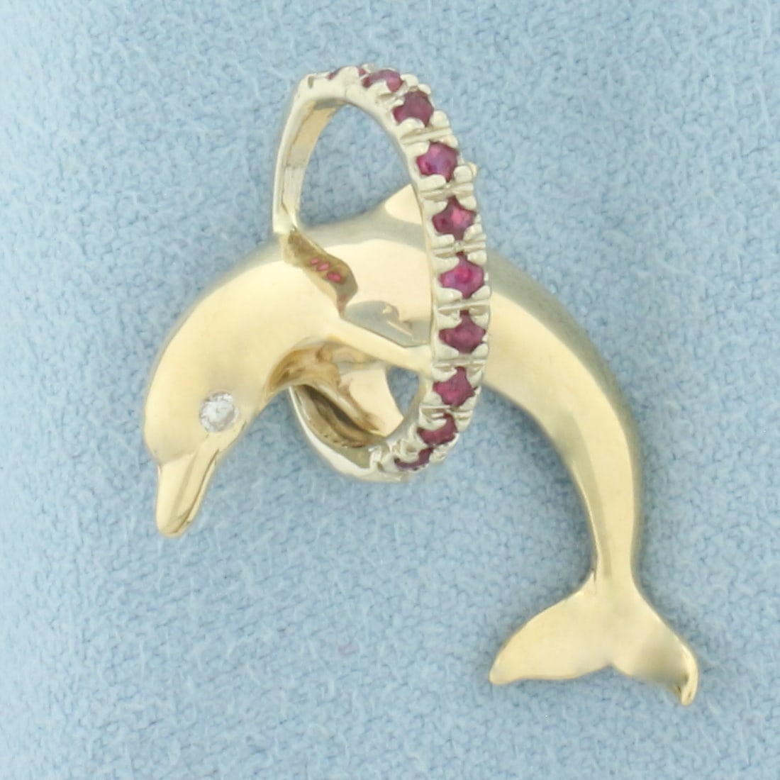 Ruby and Diamond Dolphin Pendant in 14k Yellow Gold: In 14k Yellow Gold. Contains one .01ct high quality diamond, SI clarity/H color. Also contains ten 1.5mm high quality natural Ruby gemstones, with vibrant color and excellent clarity. 1 inch long.