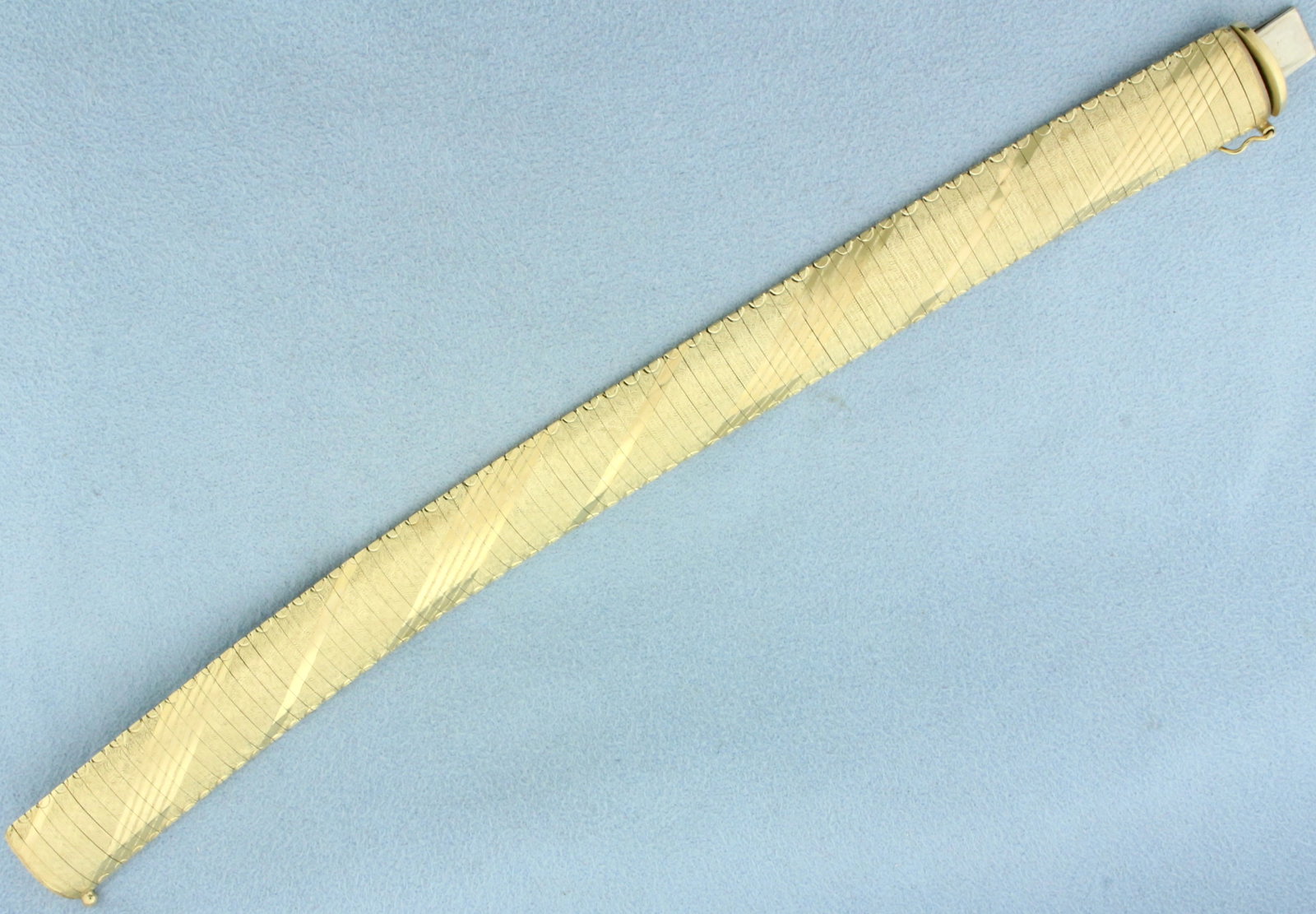 Italian Diamond Etched Omega Link Bracelet in 14k Yellow Gold: In 14k yellow gold.7 1/8 inches long. 5/8 inch wide. Safety clasp. 25.4g.