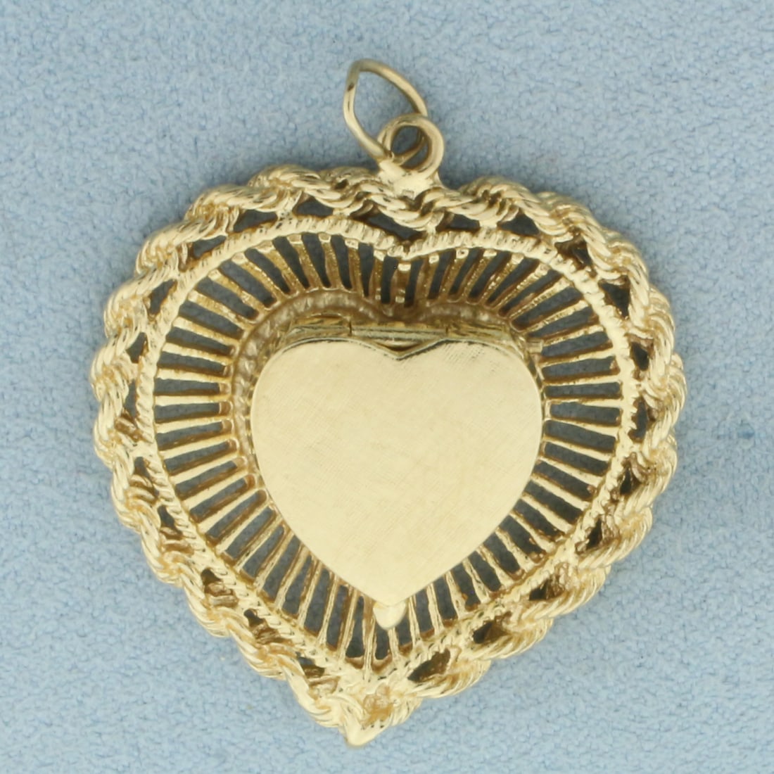 Rope Heart Locket Pendant in 14k Yellow Gold: In 14k Yellow Gold. 1.5 inches long including jump ring. 1 1/4 inches wide. Center heart opens to compartment for photo or keepsake. 9.2g.