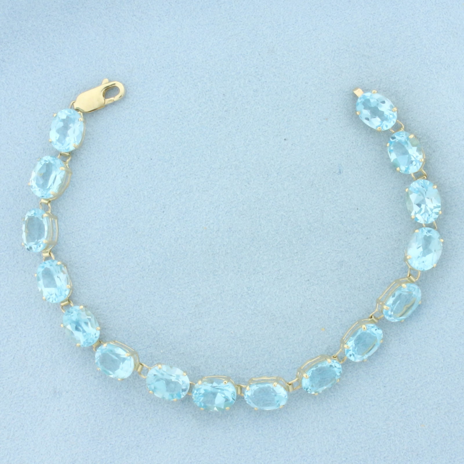 Sky Blue Topaz Tennis Bracelet in 14K Yellow Gold: In 14k yellow gold. Measures 7.5 inches long. Contains sixteen 9mm high quality natural Sky Blue Topaz gemstones, approximately 40ct TW, with bright color and excellent clarity. Lobster clasp. 12.1g