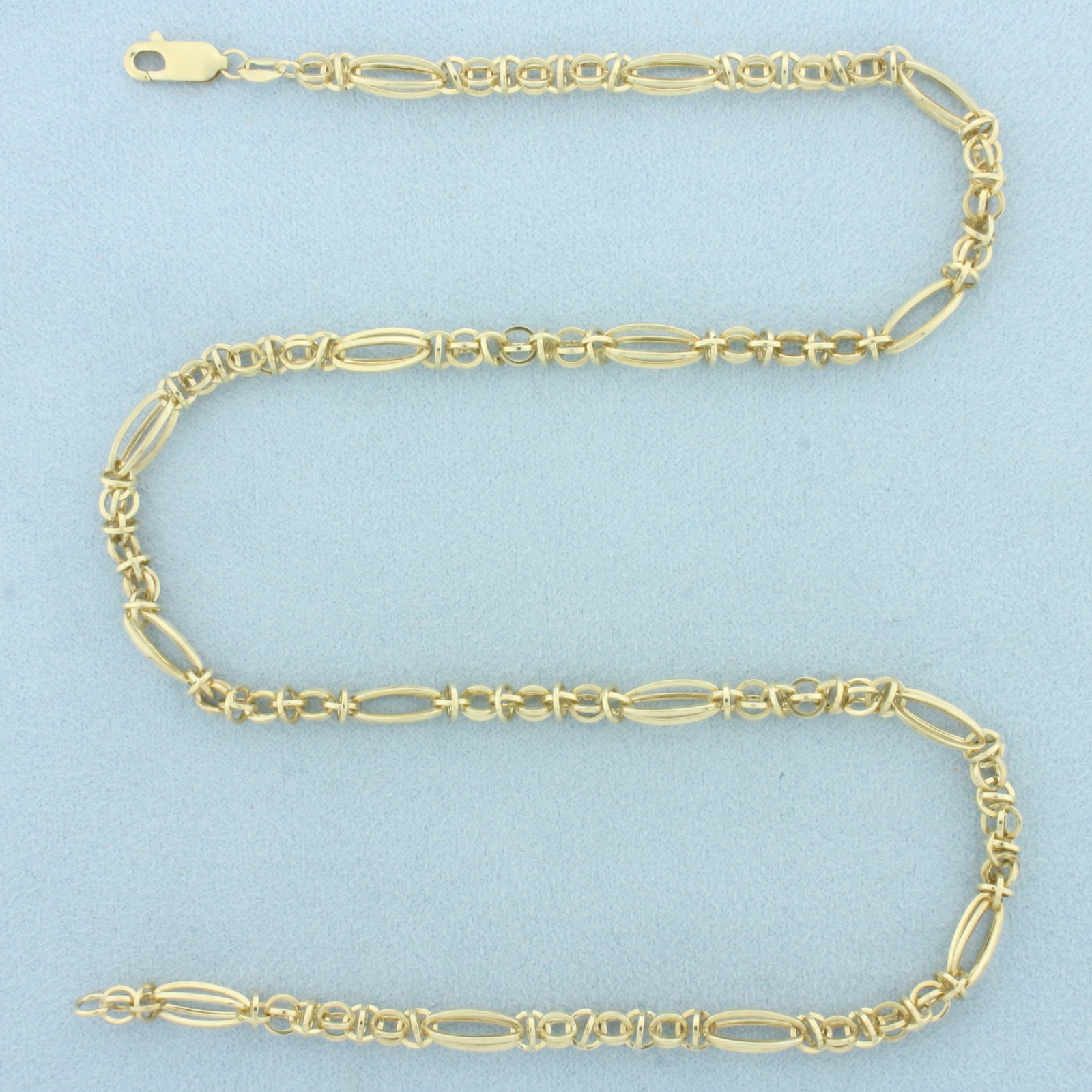 18 Inch 3D Figaro Oval and Round Link Necklace in 10k Yellow Gold: In 10k Yellow Gold. 18 inches long. 5.3mm wide at widest. Lobster clasp. 8.4g.