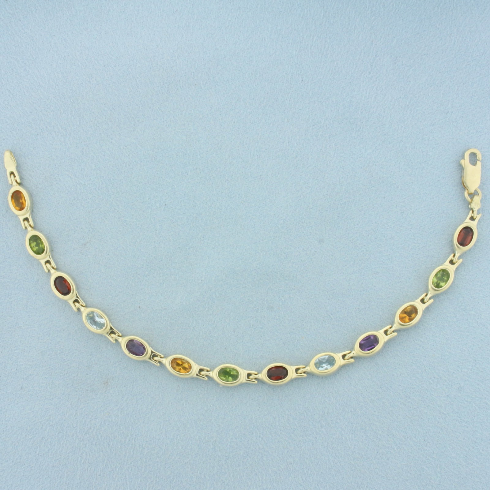 Rainbow Gemstone Bracelet In 14k Yellow Gold: In 14k yellow gold. Contains thirteen high quality natural 6mm x 4mm Garnet, Peridot, Citrine, Amethyst, and Blue Topaz gemstones, all with vibrant color and excellent clarity. 7.25 inches long. Lobst