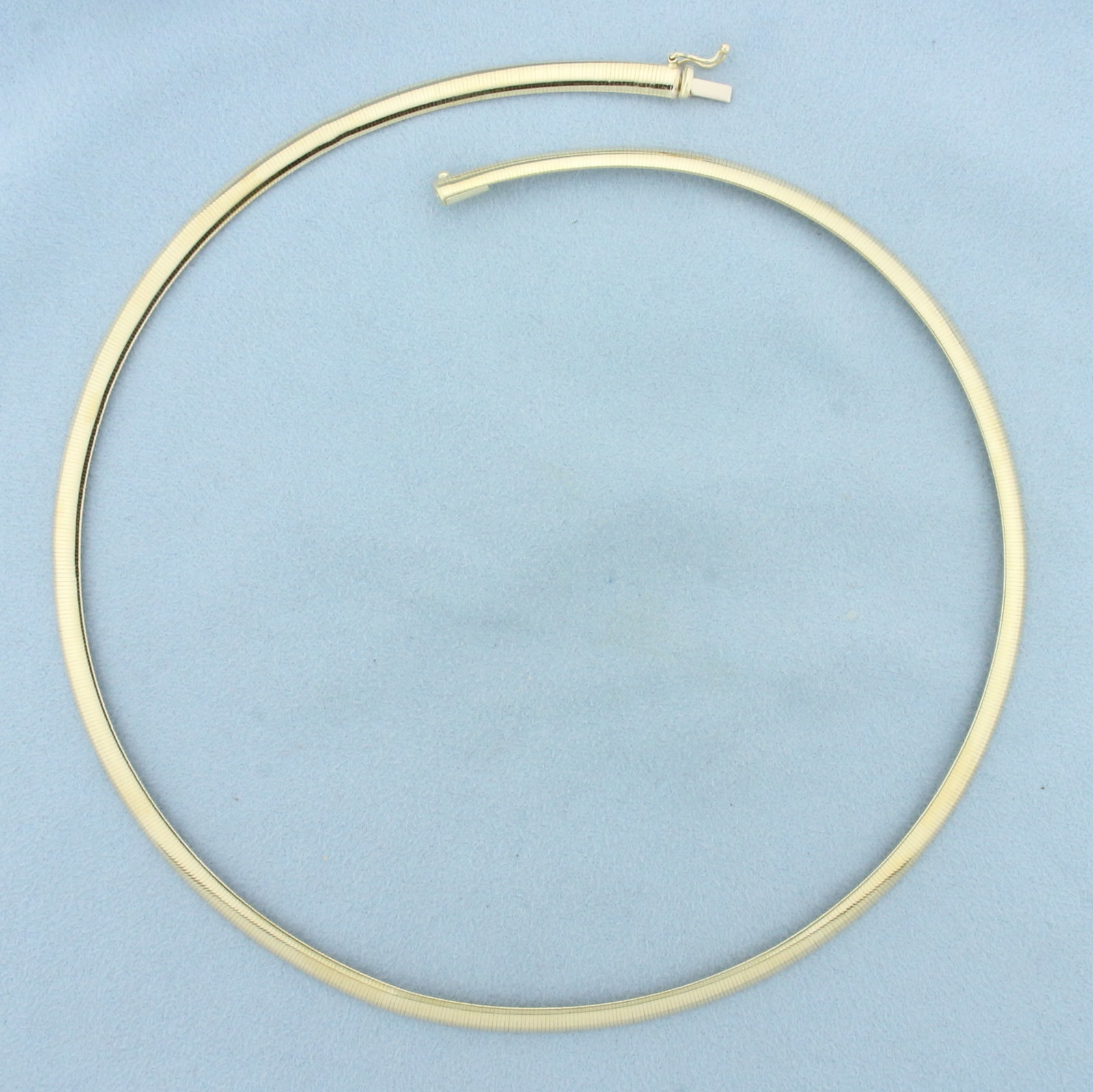 18 Inch Italian Omega Necklace in 14k Yellow Gold: In 14k Yellow Gold. 18 inches long. 5mm wide. Italian made. Slide clasp with safety latch. 13.8g.