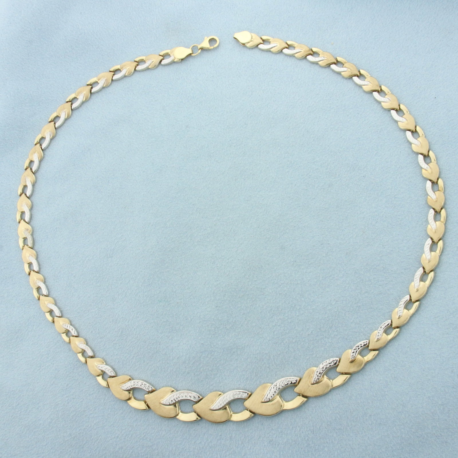 Heart Link Necklace in 10k Yellow and White Gold: In 10k Yellow and White Gold. 17 1/2 inches long. 10.7mm wide at widest point. Matte and high polish finish, diamond cut, for unique look. Lobster clasp. 11.1g.