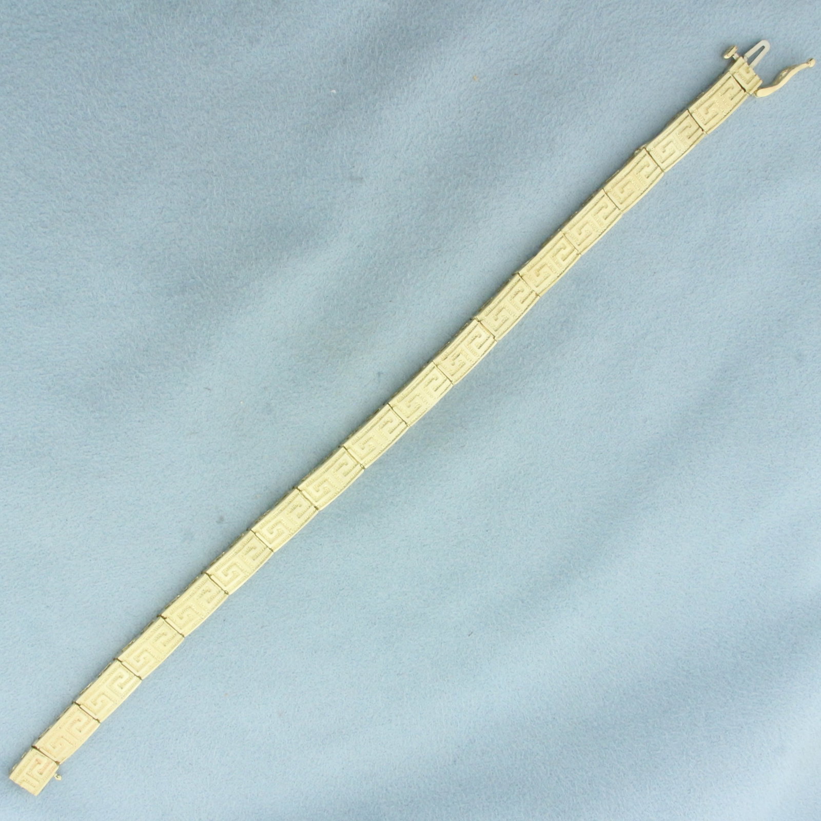 Greek Key Bracelet in 14K Yellow Gold: In 14k yellow gold. 7 1/2 inches long, 1/4 inch wide. Concealed slide clasp with safety latch. 14.6g.