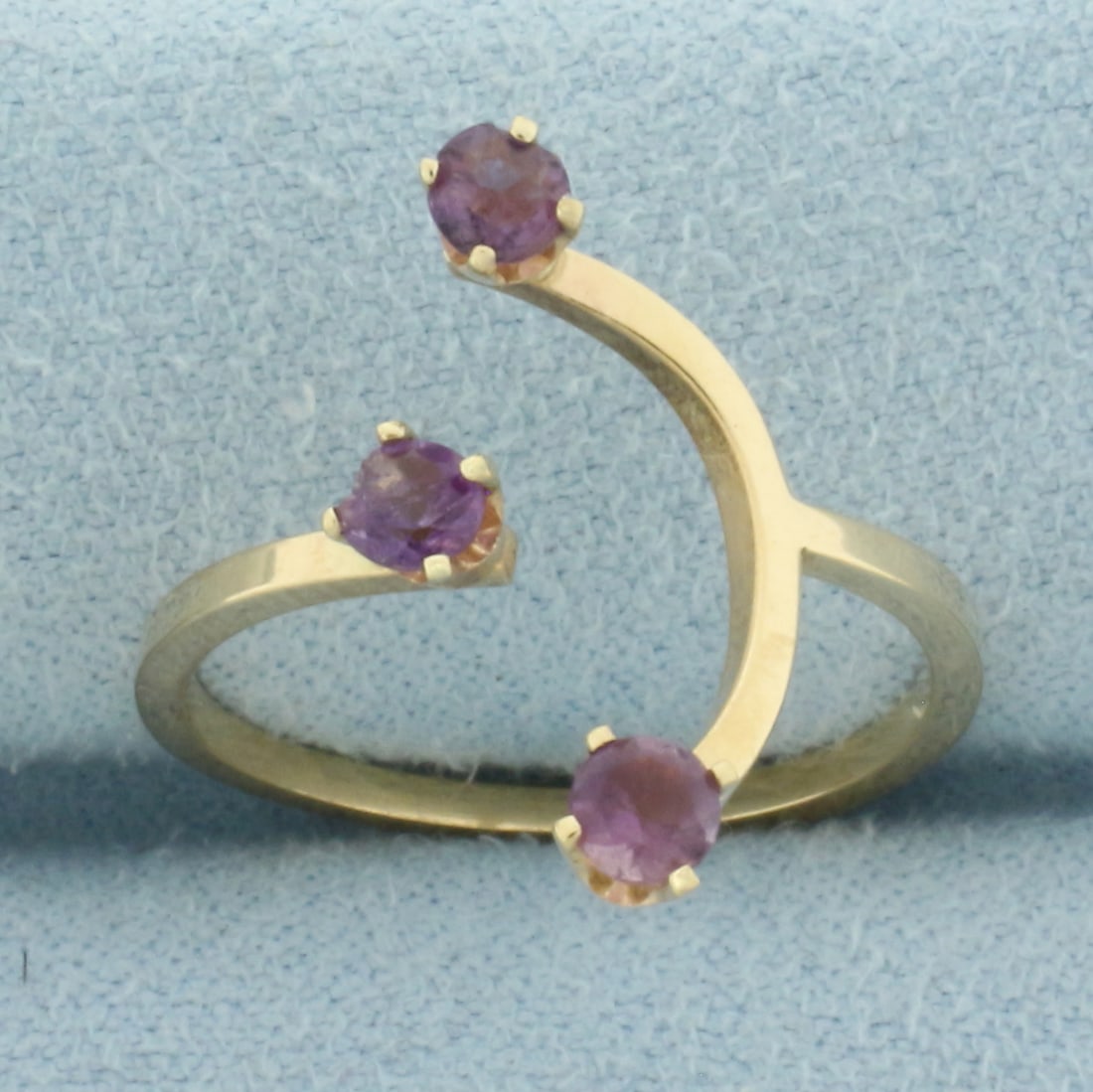 Amethyst Abstract Design Ring in 14k Yellow Gold: In 14k Yellow Gold. Contains three 3mm high quality natural Amethyst gemstones with vibrant color and excellent clarity. One amethyst has small chip, not noticeable. 18.5mm wide at widest. Adjustable