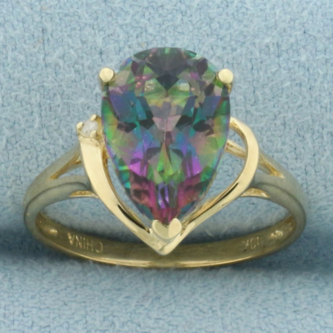 Mystic Topaz and Diamond Ring in 10k Yellow Gold: In 10k Yellow Gold. Contains one 13mm high quality pear cut natural Mystic Topaz gemstone, approximately 3cts, with vibrant color and excellent clarity. Also contains one 1/2pt high quality diamond. S